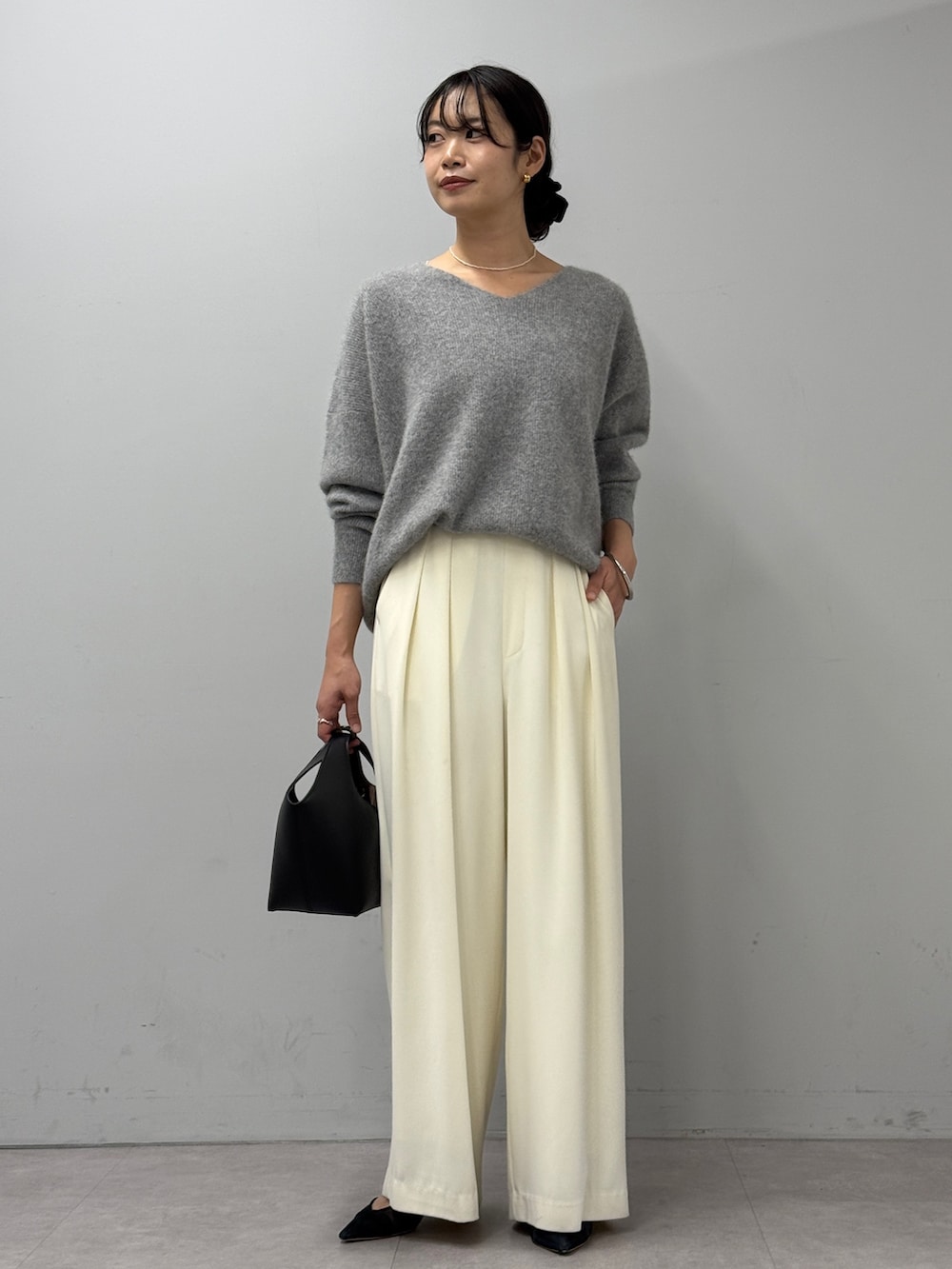 ホワイト系のスラックス、ブルー系のデニムジャケット、グレー系のニット/セーターを着用したレディースの秋コーディネートの4枚目の写真