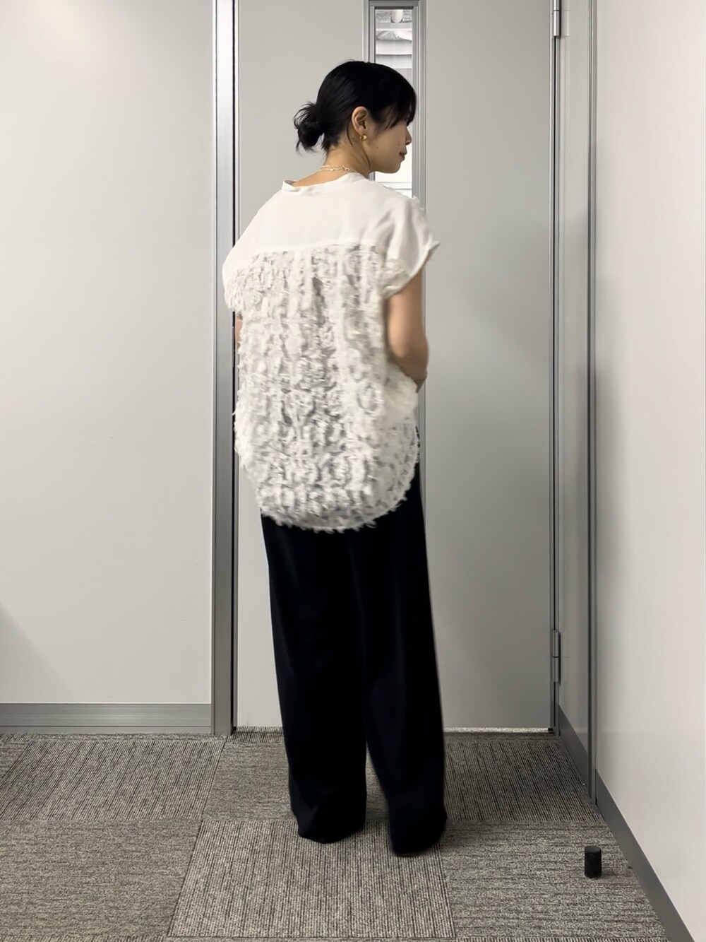 ホワイト系のシャツ/ブラウス、ブラック系のスラックス、ホワイト系のショルダーバッグを着用したレディースの春コーディネートの3枚目の写真