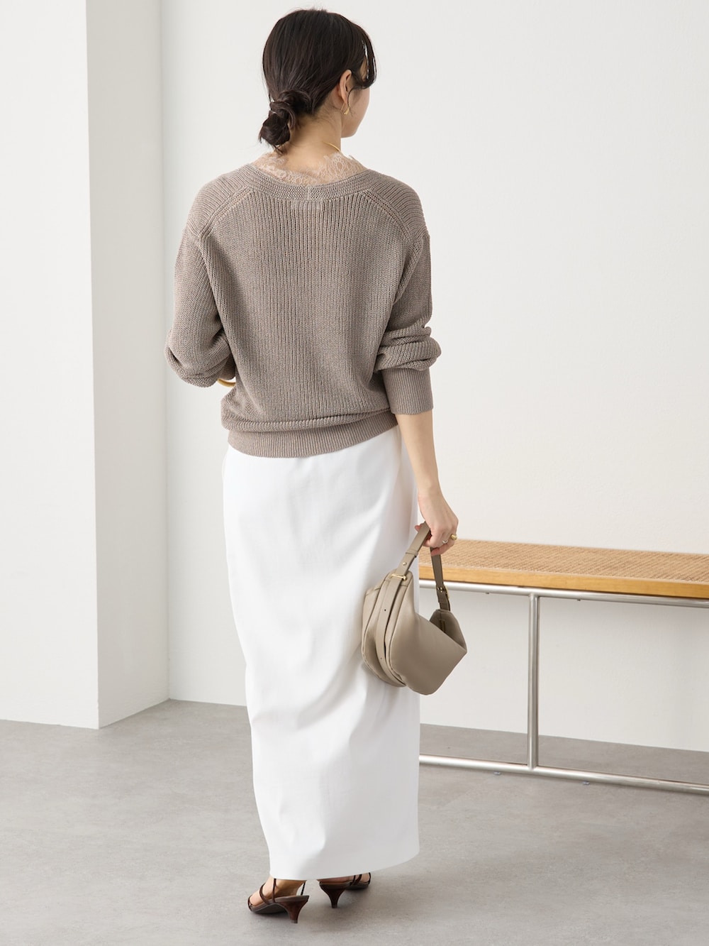 ブラウン系のニット/セーター、ホワイト系のスカート、ブラック系のサンダルを着用したレディースの冬コーディネートの3枚目の写真