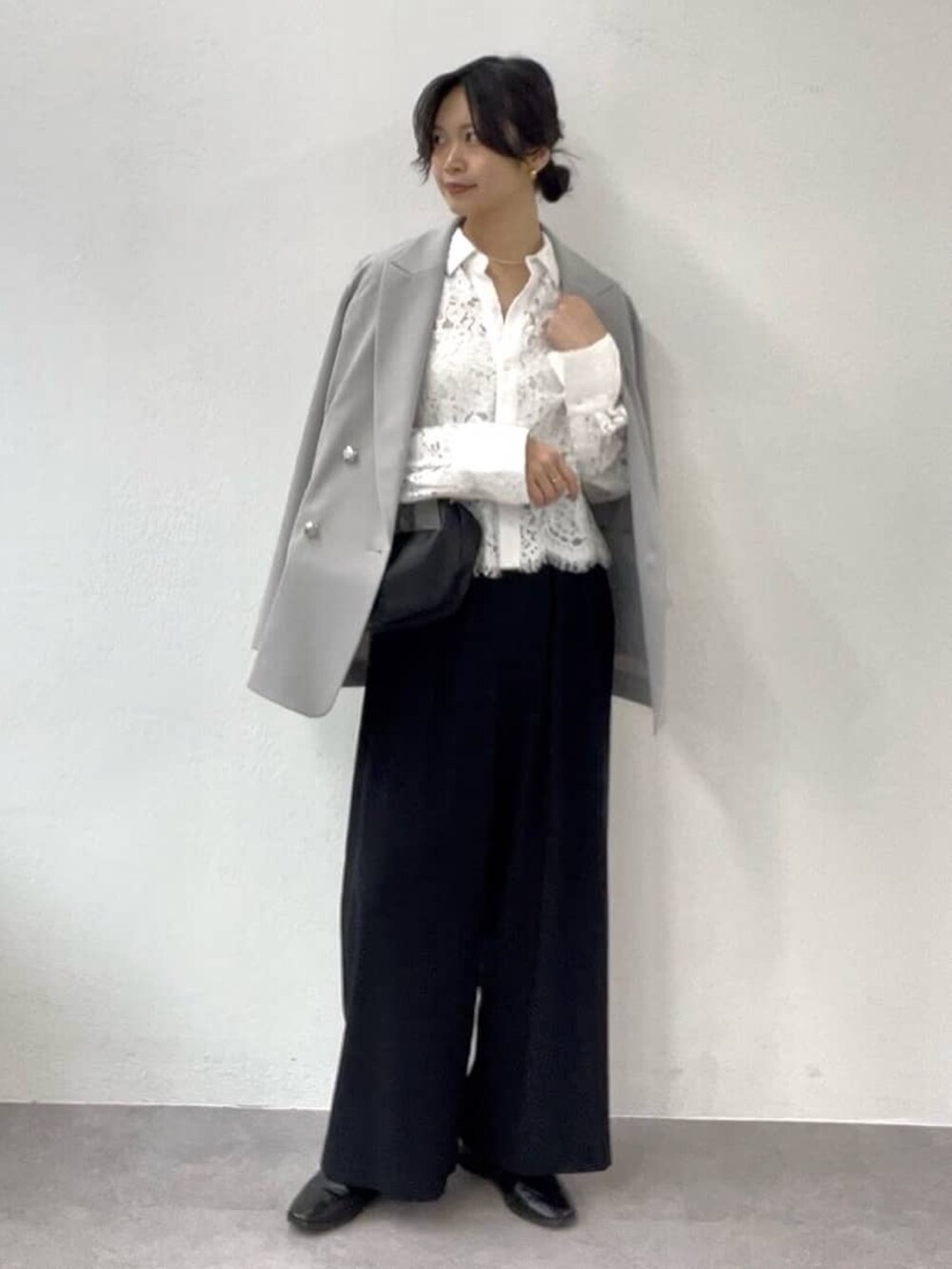 ブラック系のスラックス、グレー系のテーラードジャケット、ホワイト系のシャツ/ブラウスを着用したレディースの冬コーディネートの2枚目の写真