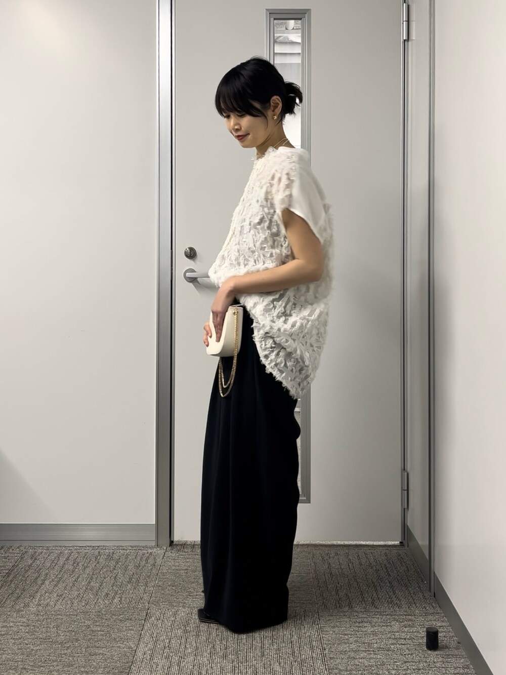 ホワイト系のシャツ/ブラウス、ブラック系のスラックス、ホワイト系のショルダーバッグを着用したレディースの春コーディネートの2枚目の写真