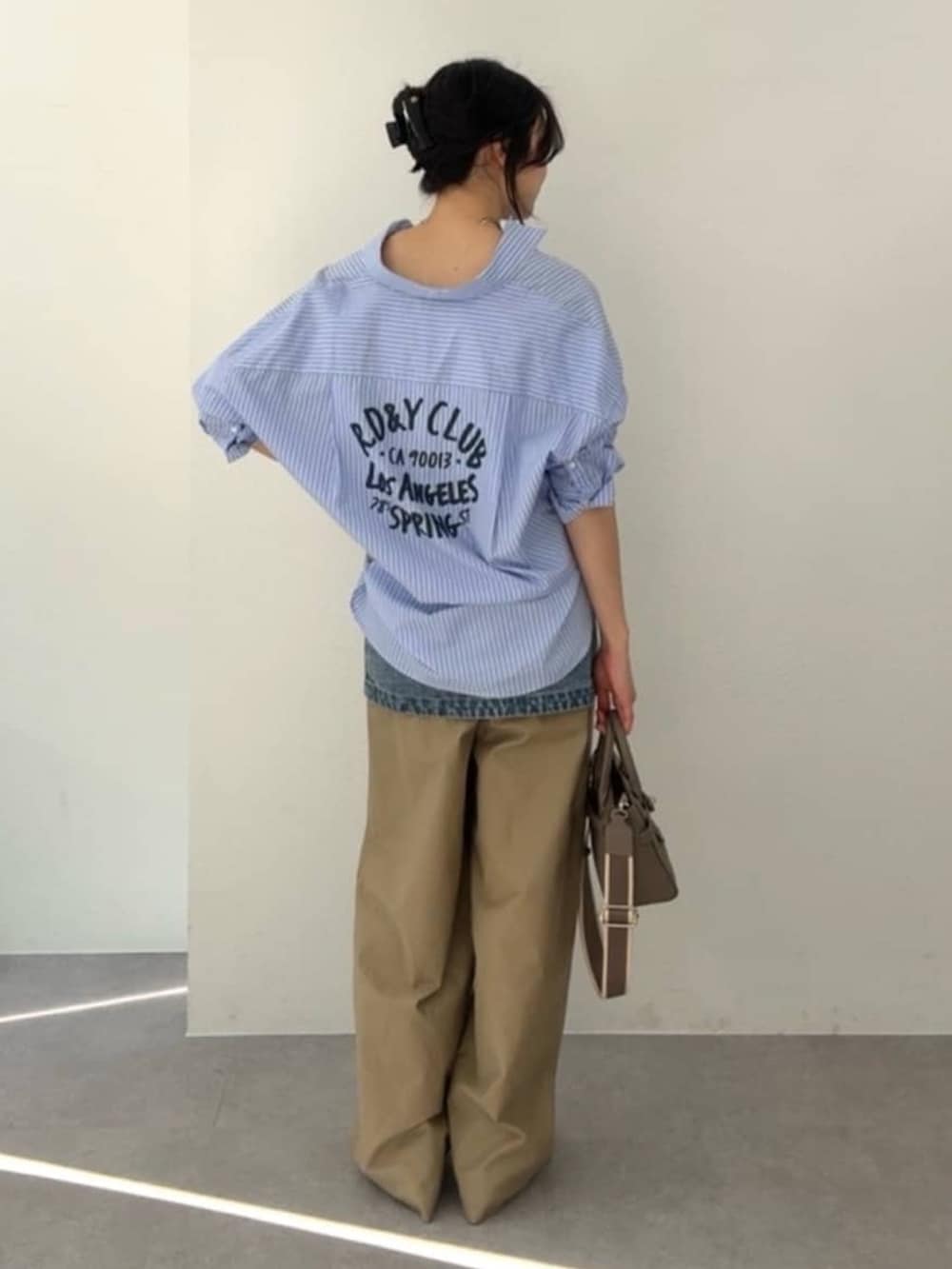 ブルー系のシャツ/ブラウス、ブルー系のデニムスカート、ベージュ系のチノパンツを着用したレディースの冬コーディネートの3枚目の写真