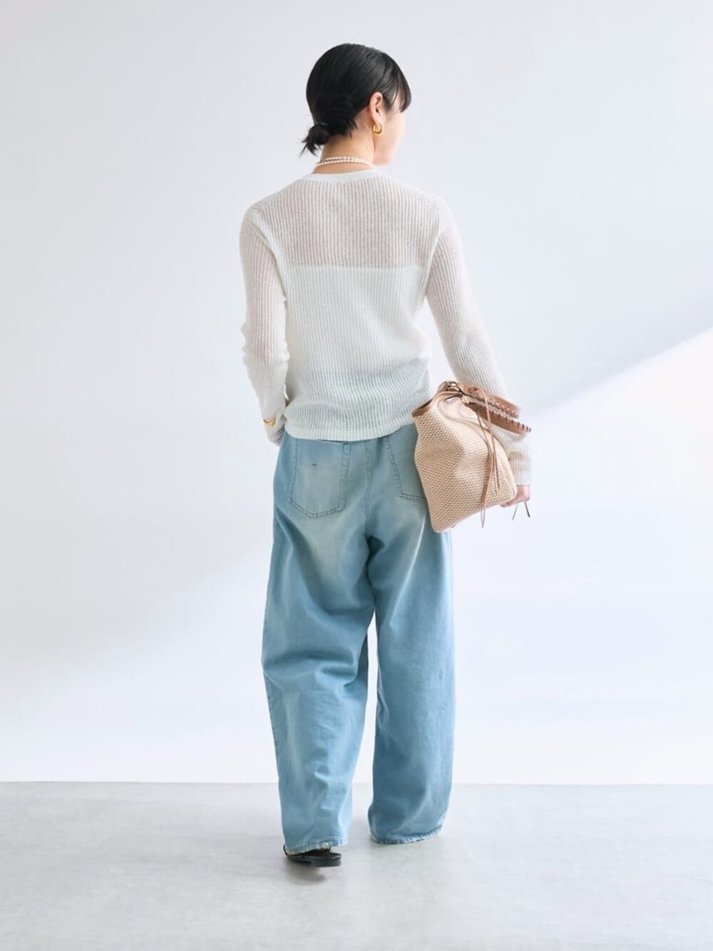 ブルー系のデニムパンツ、ホワイト系のカーディガン/ボレロ、ブラウン系のトートバッグを着用したレディースの夏コーディネートの3枚目の写真