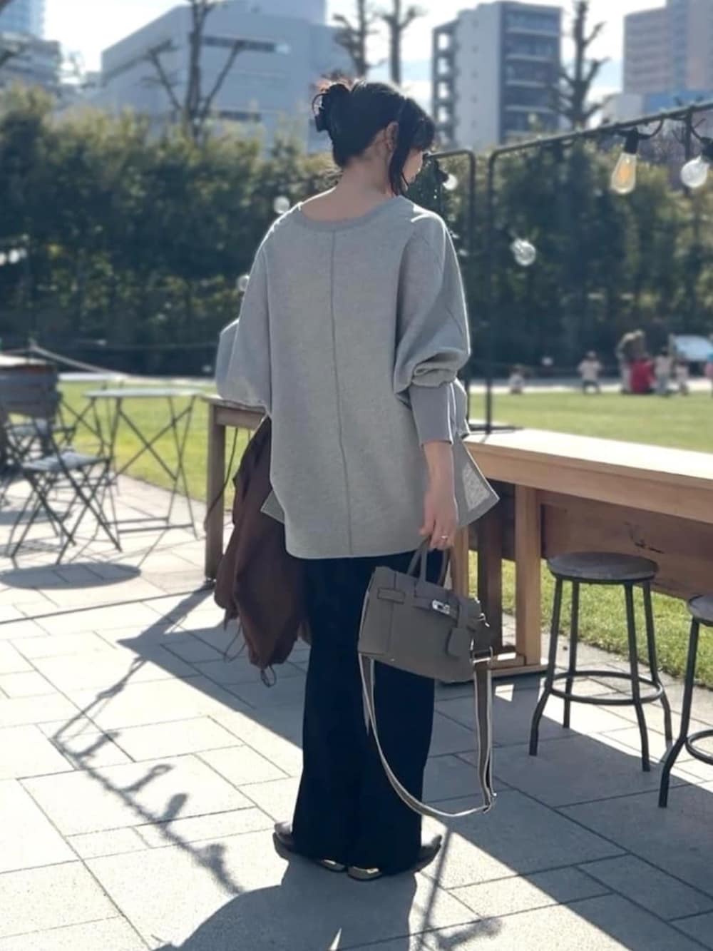 グレー系のスウェット、ブルー系のデニムスカート、ブラック系のその他パンツを着用したレディースの冬コーディネートの3枚目の写真