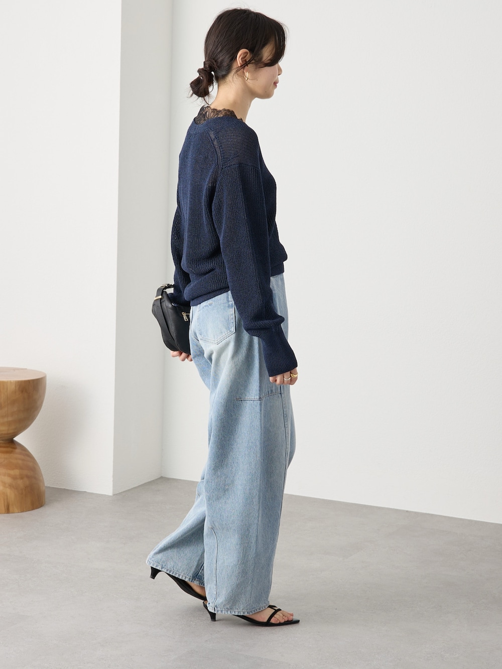 ブルー系のニット/セーター、ブルー系のデニムパンツ、ブラック系のサンダルを着用したレディースの冬コーディネートの2枚目の写真