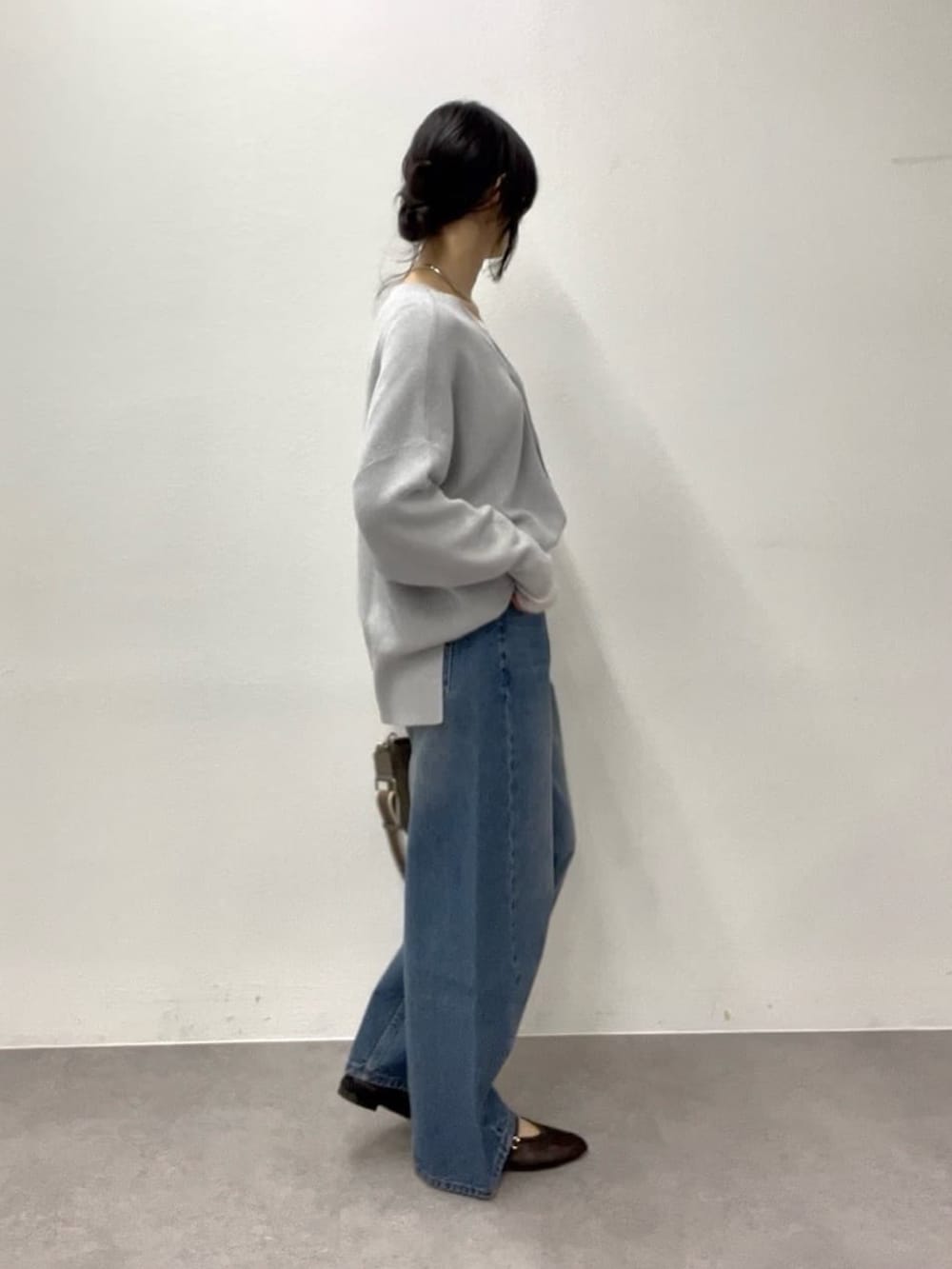 ホワイト系のTシャツ/カットソー、グレー系のニット/セーター、グレー系のトートバッグを着用したレディースの冬コーディネートの3枚目の写真