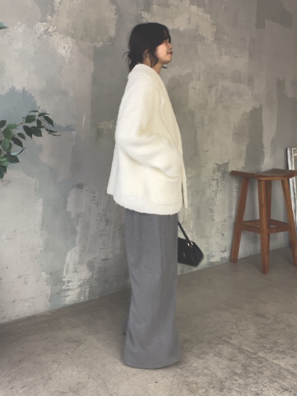 ホワイト系のその他アウター、ホワイト系のTシャツ/カットソー、グレー系のスラックスを着用したレディースの冬コーディネートの2枚目の写真