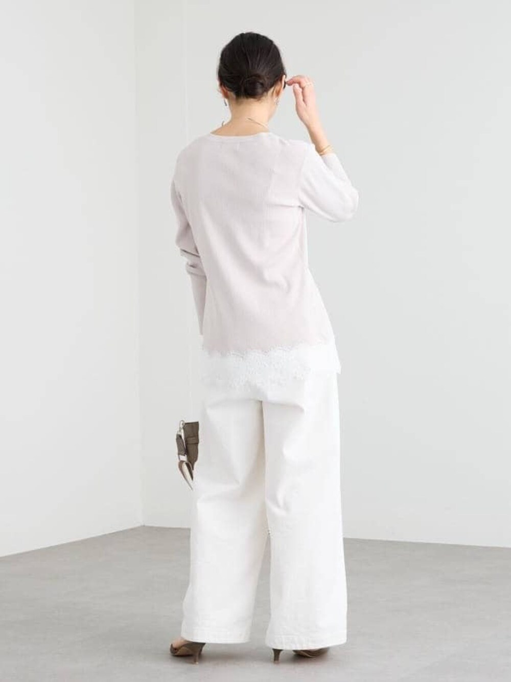 グレー系のトートバッグ、ホワイト系のデニムパンツ、グレー系のその他シューズを着用したレディースの冬コーディネートの3枚目の写真