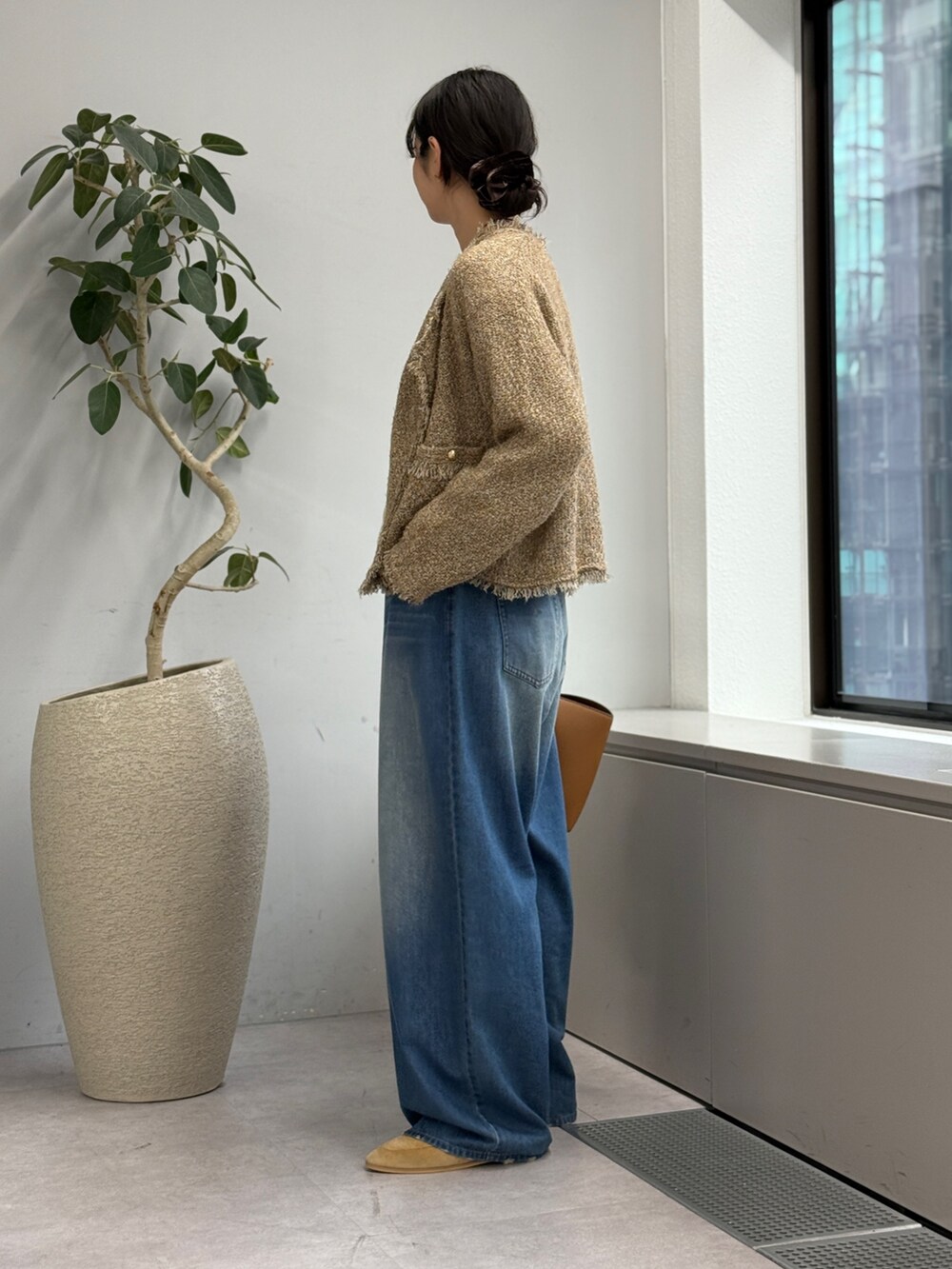 ブルー系のデニムパンツ、ベージュ系のカーディガン/ボレロ、ホワイト系のシャツ/ブラウスを着用したレディースの秋コーディネートの2枚目の写真