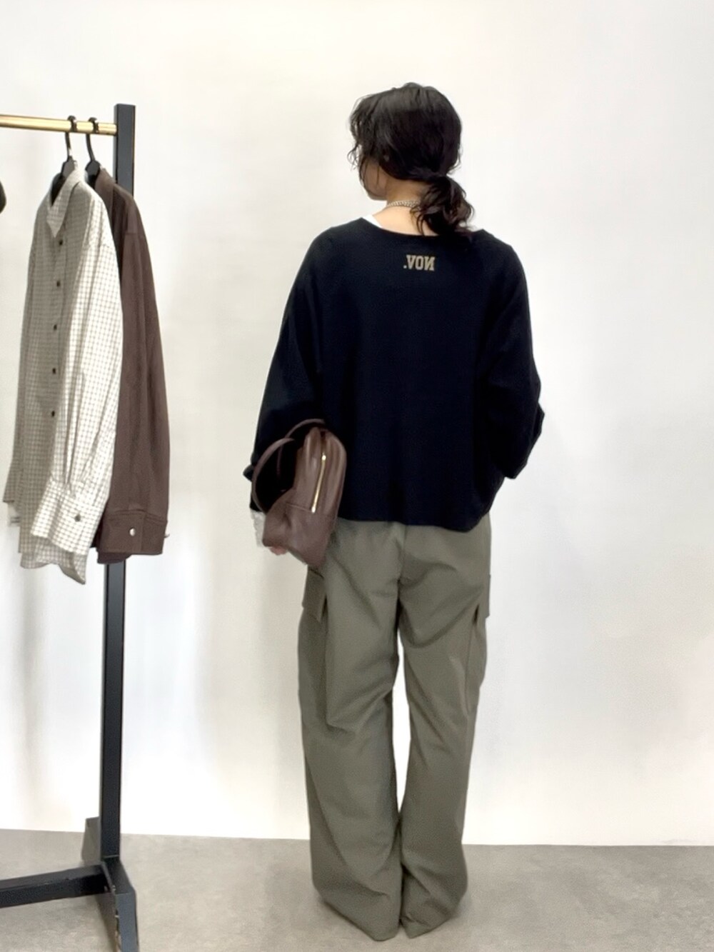 グリーン系のカーゴパンツ、グレー系のパンプス、ブラウン系のボストンバッグを着用したレディースの秋コーディネートの4枚目の写真