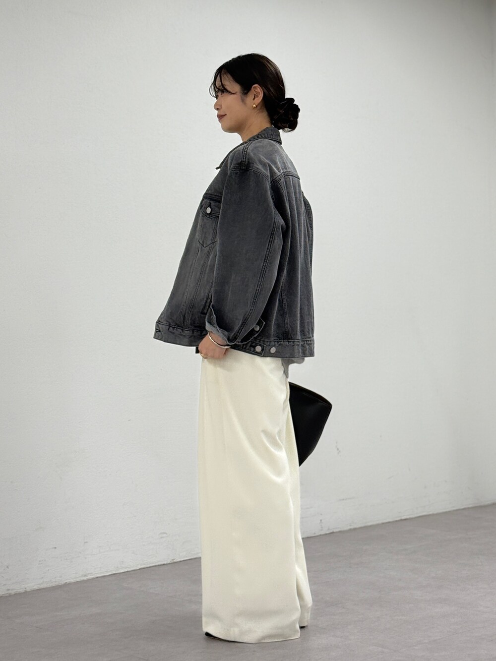 ホワイト系のスラックス、ブルー系のデニムジャケット、グレー系のニット/セーターを着用したレディースの秋コーディネートの2枚目の写真