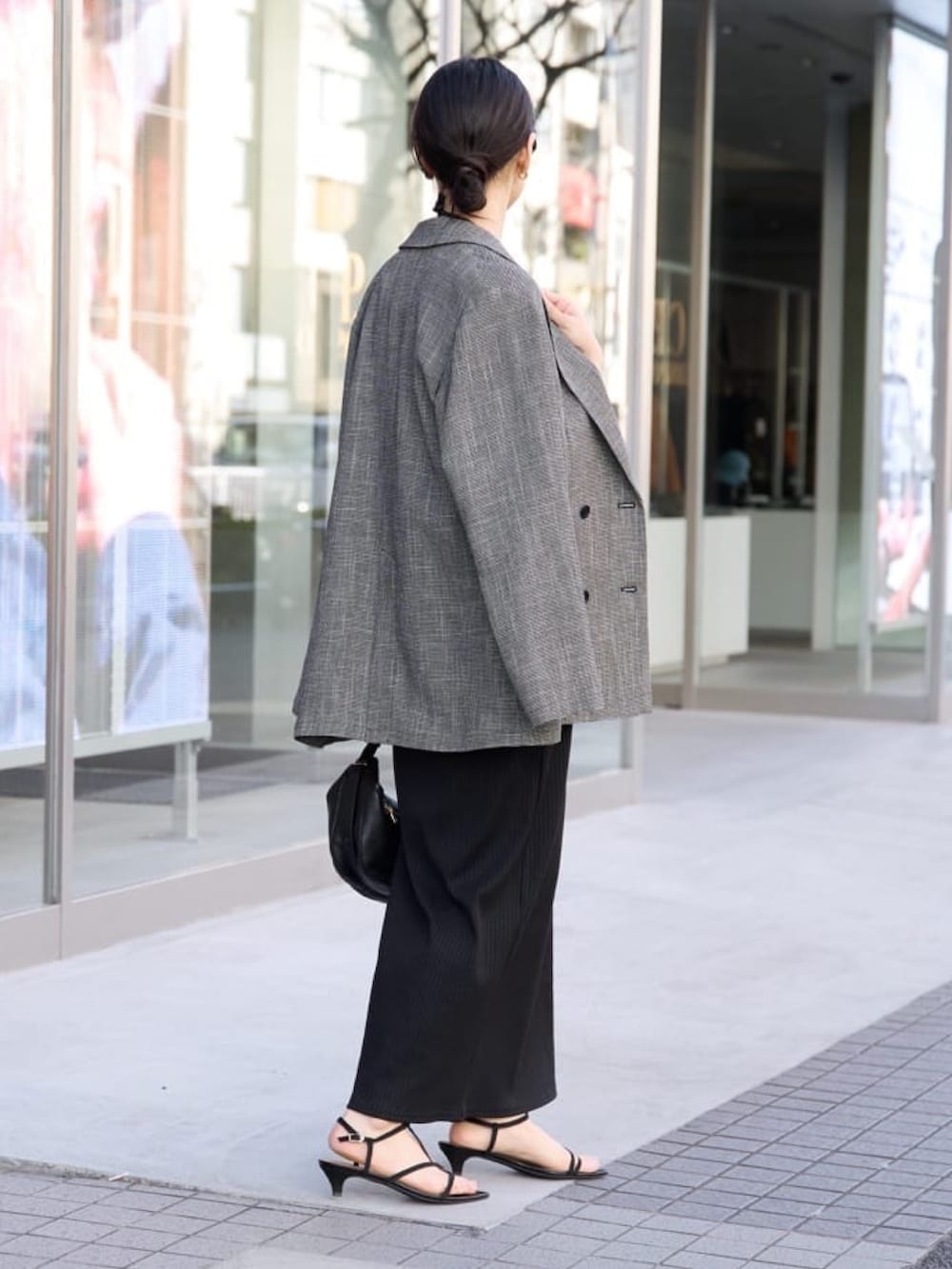 ブラック系のワンピース、ブラック系のサンダル、ブラック系のテーラードジャケットを着用したレディースの冬コーディネートの2枚目の写真