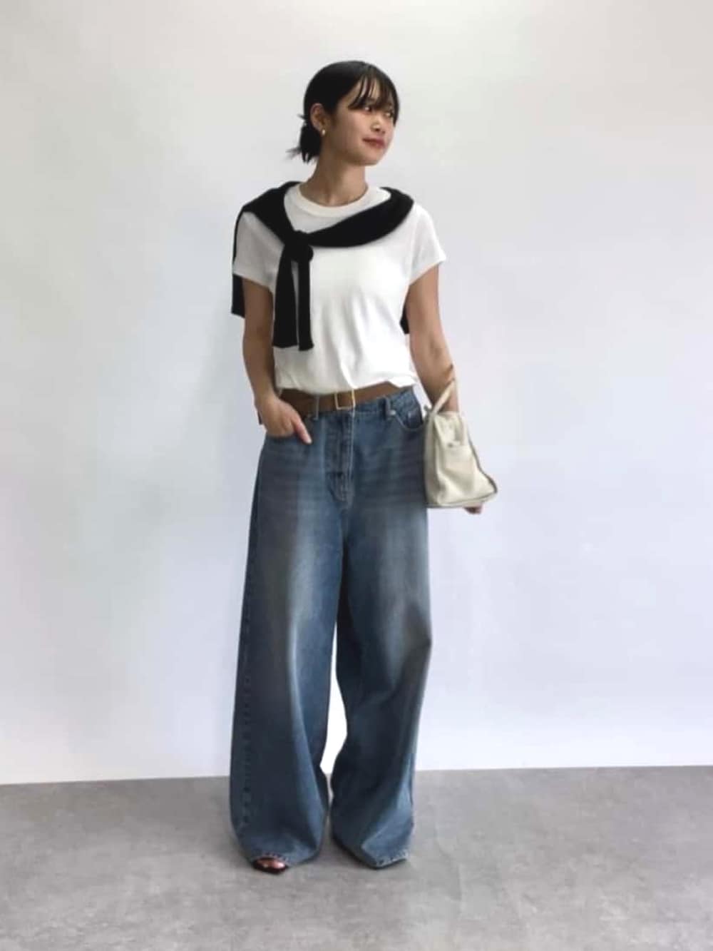 ブルー系のデニムパンツ、ブラック系のカーディガン/ボレロ、ホワイト系のTシャツ/カットソーを着用したレディースの春コーディネートの4枚目の写真