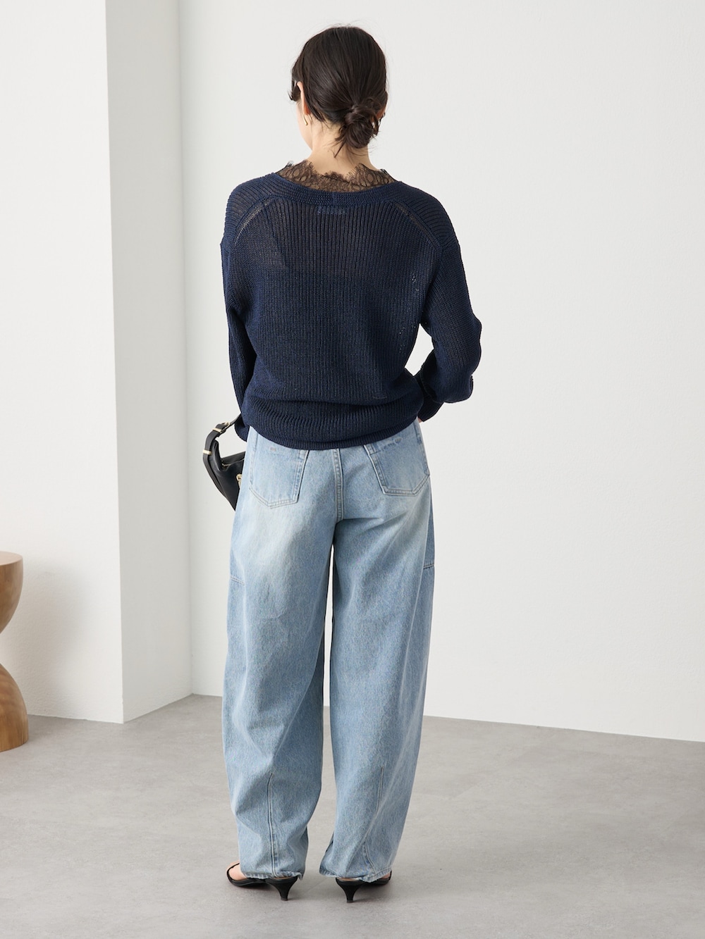 ブルー系のニット/セーター、ブルー系のデニムパンツ、ブラック系のサンダルを着用したレディースの冬コーディネートの3枚目の写真