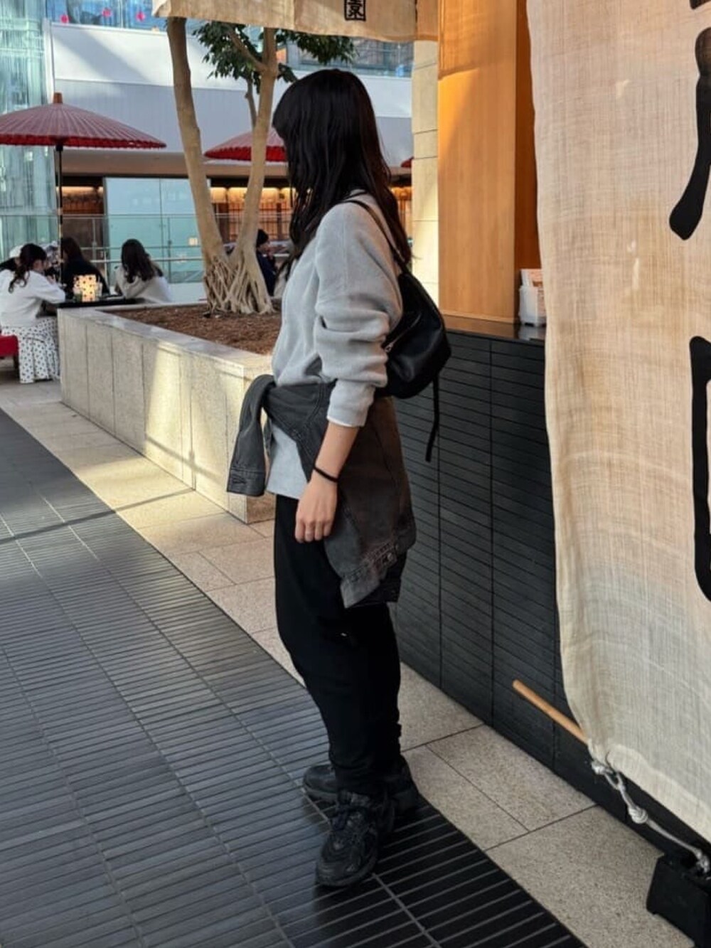 グレー系のニット/セーター、グレー系のTシャツ/カットソー、ブラック系のその他パンツを着用したレディースの冬コーディネートの2枚目の写真