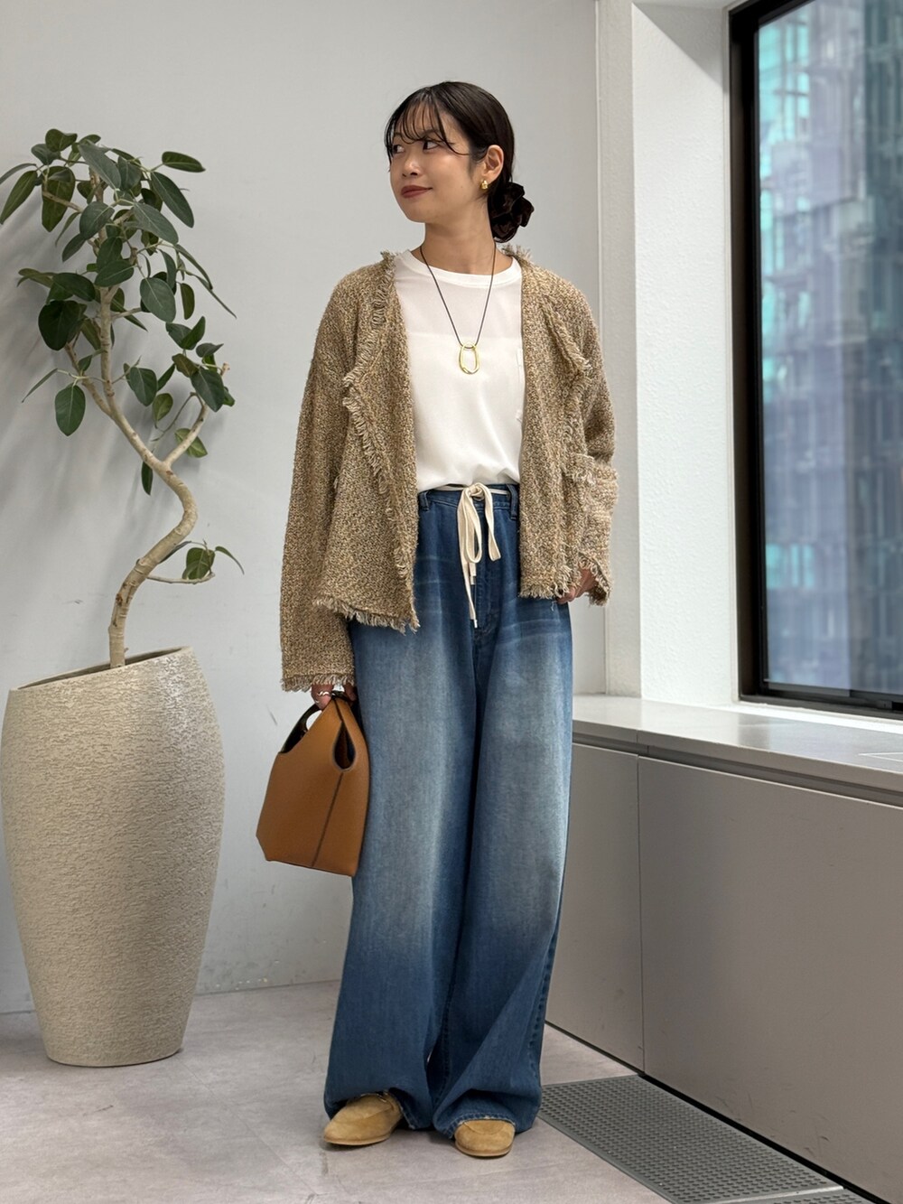 ブルー系のデニムパンツ、ベージュ系のカーディガン/ボレロ、ホワイト系のシャツ/ブラウスを着用したレディースの秋コーディネートの4枚目の写真