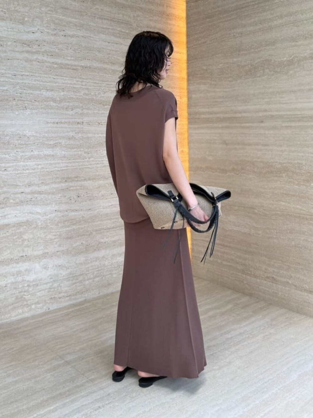 ブラウン系のスカート、ブラック系のトートバッグ、ブラウン系のニット/セーターを着用したレディースの夏コーディネートの4枚目の写真