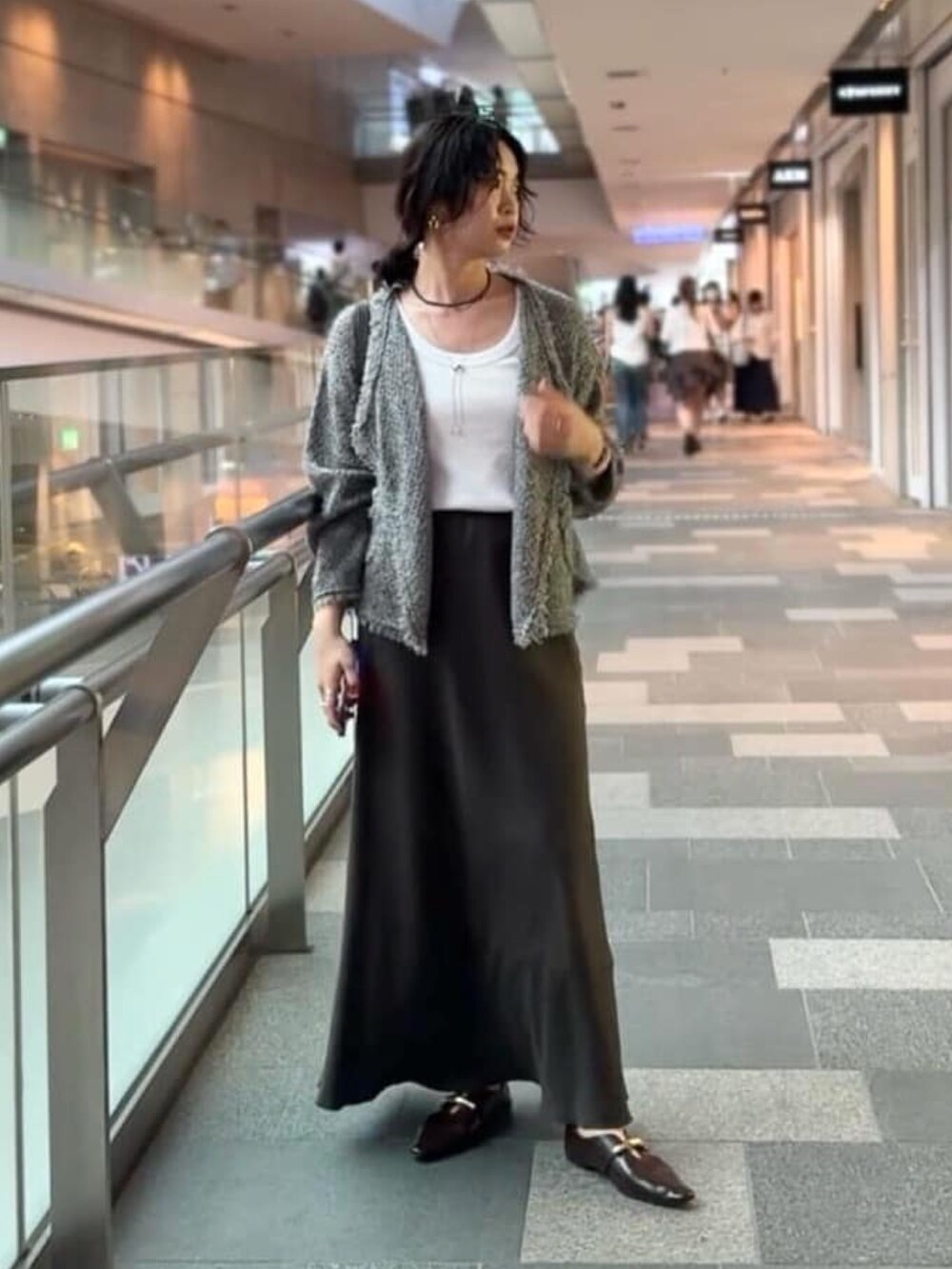 ブラウン系のスカート、ブラック系のその他シューズ、グレー系のカーディガン/ボレロを着用したレディースの夏コーディネートの2枚目の写真