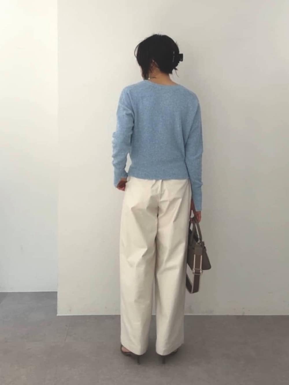 ブルー系のカーディガン/ボレロ、ホワイト系のチノパンツ、グレー系のトートバッグを着用したレディースの春コーディネートの3枚目の写真