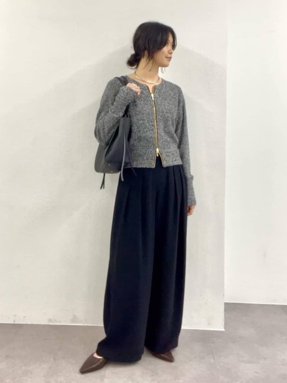 ブラック系のカーディガン/ボレロ、ブラック系のスラックス、ブラウン系のその他シューズを着用したレディースの冬コーディネートの2枚目の写真