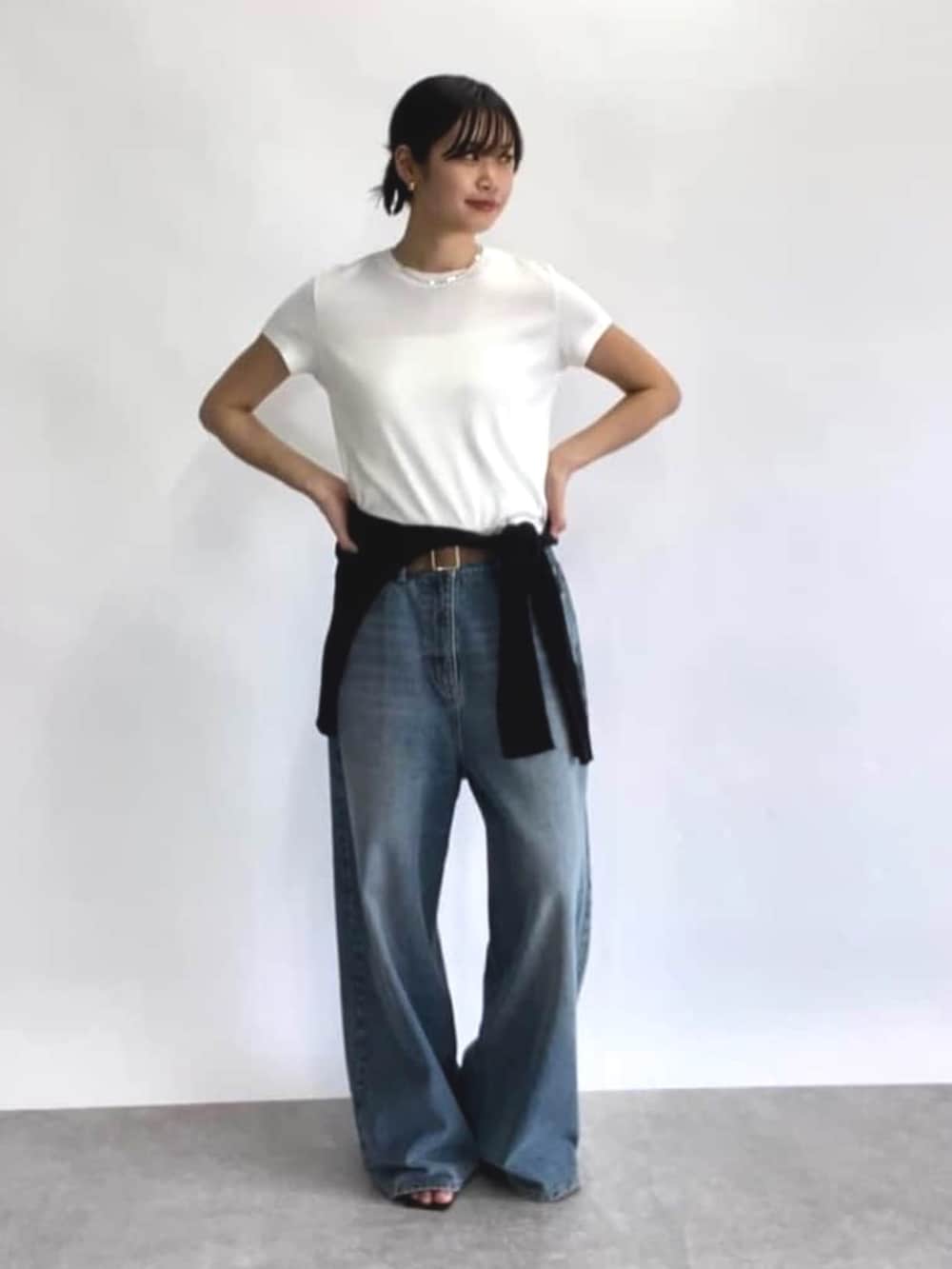 ブルー系のデニムパンツ、ブラック系のカーディガン/ボレロ、ホワイト系のTシャツ/カットソーを着用したレディースの春コーディネートの3枚目の写真