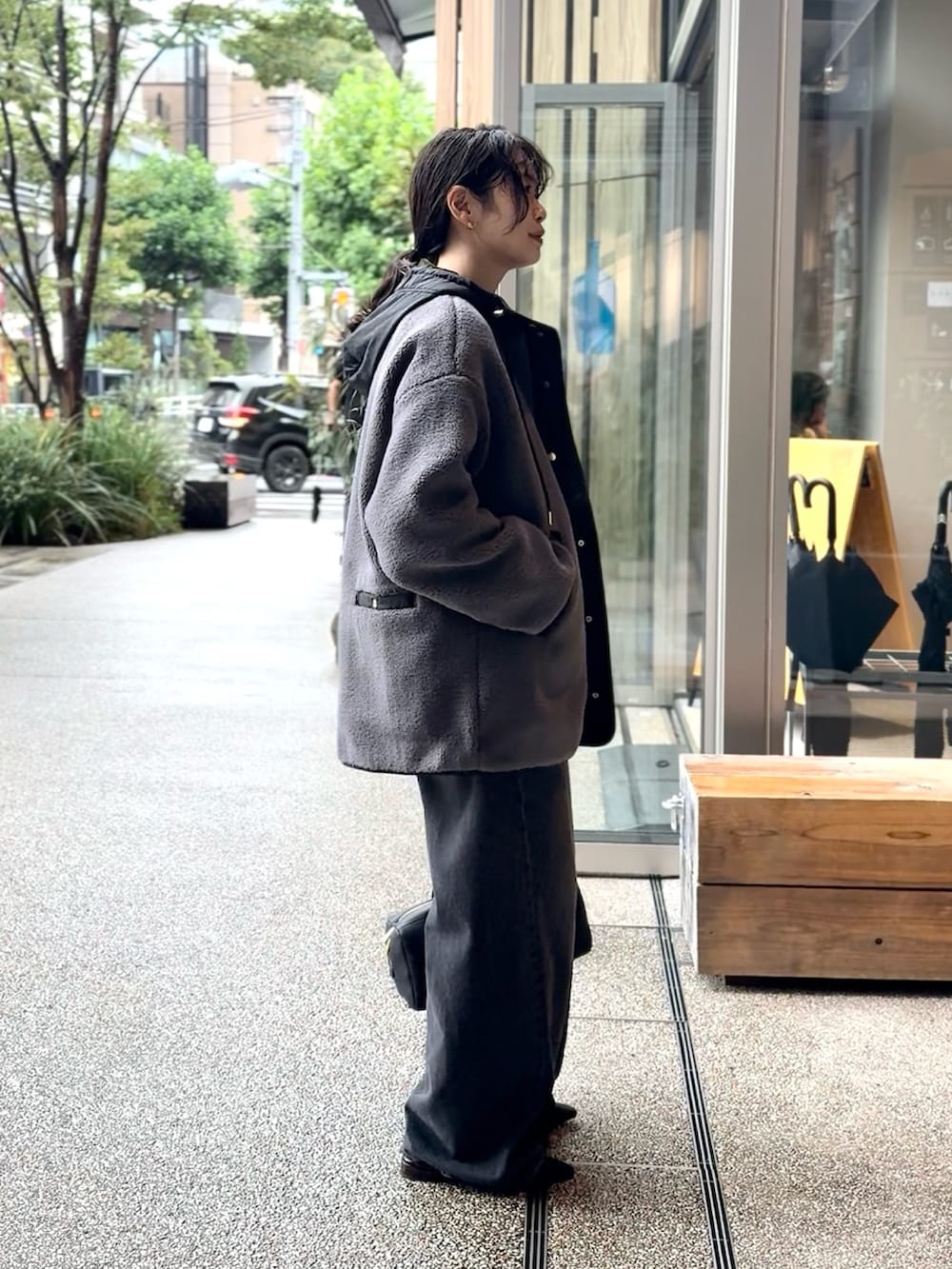 グレー系のその他アウター、ブラック系のスウェット、ブラック系のデニムパンツを着用したレディースの秋コーディネートの2枚目の写真