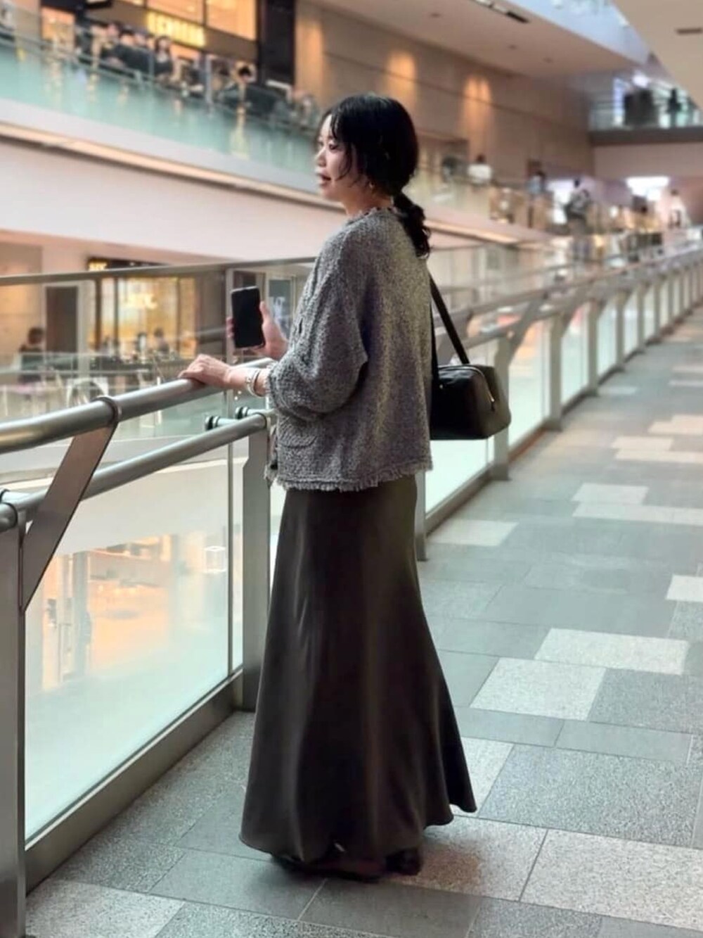 ブラウン系のスカート、ブラック系のその他シューズ、グレー系のカーディガン/ボレロを着用したレディースの夏コーディネートの3枚目の写真