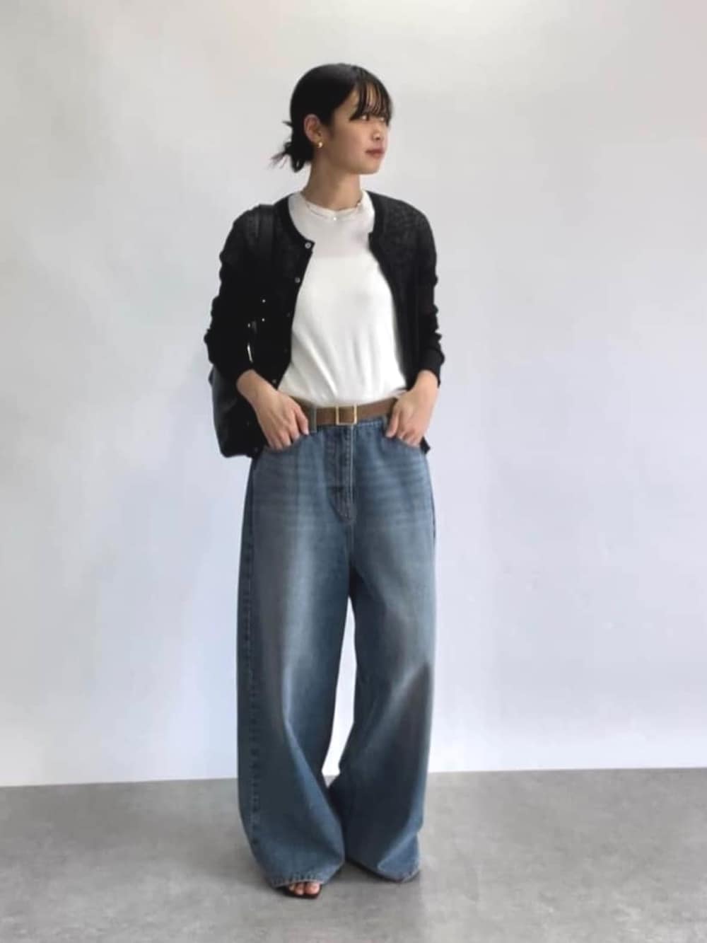 ブルー系のデニムパンツ、ブラック系のカーディガン/ボレロ、ホワイト系のTシャツ/カットソーを着用したレディースの春コーディネートの2枚目の写真