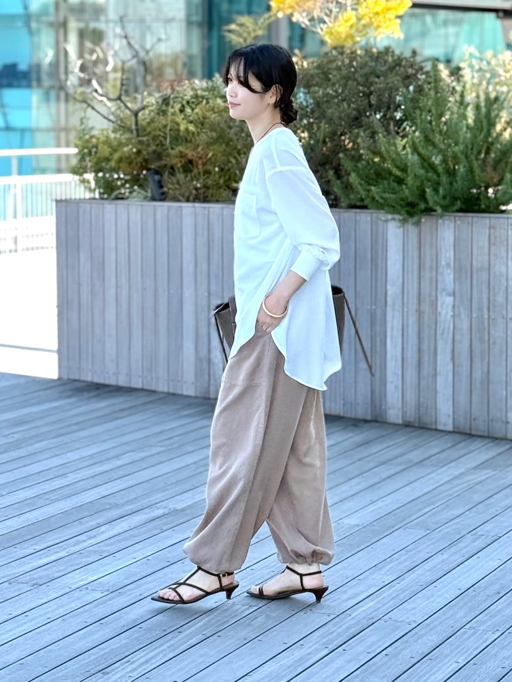 ホワイト系のシャツ/ブラウス、ブラウン系のその他パンツ、ブラウン系のサンダルを着用したレディースの春コーディネートの2枚目の写真