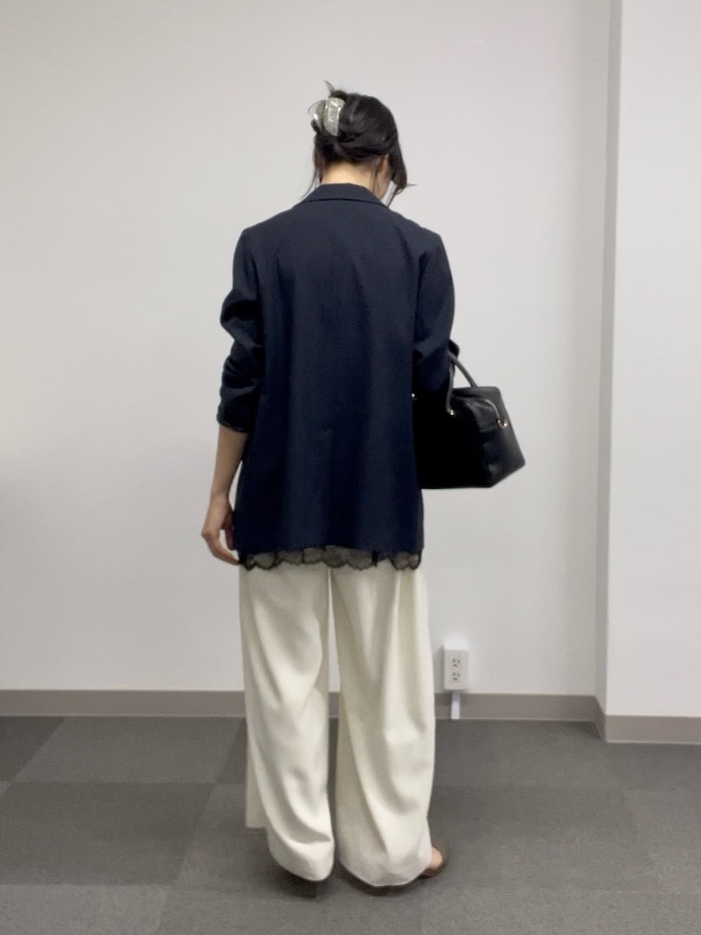 ブラック系のキャミソール、ホワイト系のスラックス、グレー系のその他シューズを着用したレディースの春コーディネートの3枚目の写真