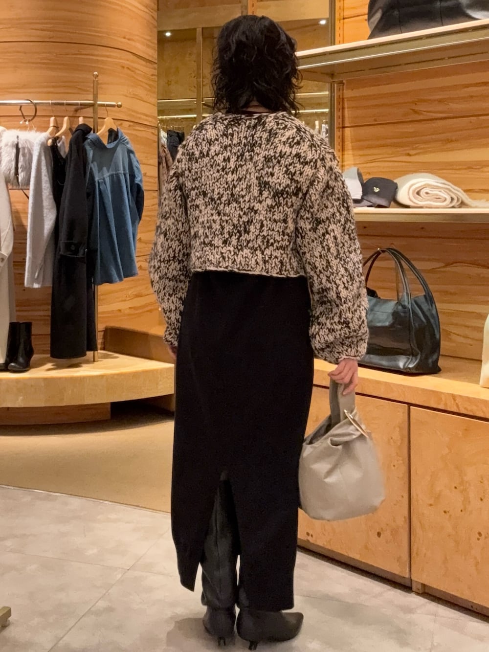 ブラック系のカーディガン/ボレロ、ブラック系のワンピース、ブラック系のブーツを着用したレディースの秋コーディネートの2枚目の写真