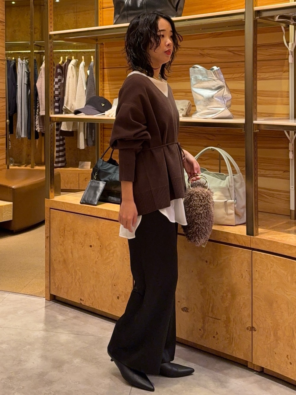 ブラウン系のニット/セーター、ホワイト系のシャツ/ブラウス、ブラック系のその他パンツを着用したレディースの秋コーディネートの2枚目の写真