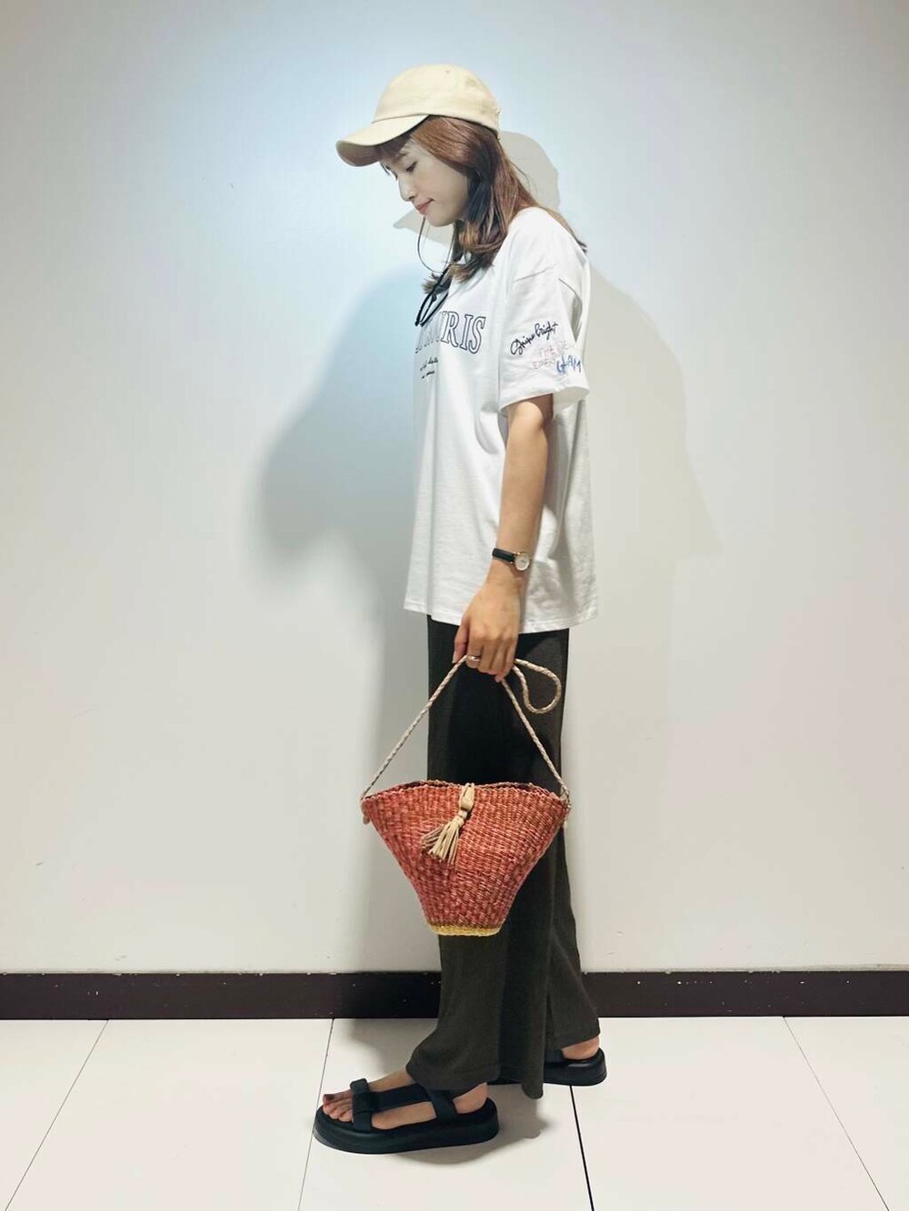 ピンク系のショルダーバッグ、ブラウン系のその他パンツ、ホワイト系のTシャツ/カットソーを着用したレディースの夏コーディネートの2枚目の写真