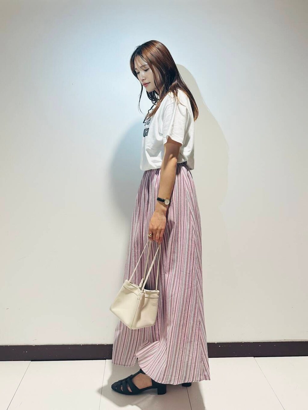 ホワイト系のTシャツ/カットソー、ピンク系のスカート、ホワイト系のハンドバッグを着用したレディースの春コーディネートの2枚目の写真