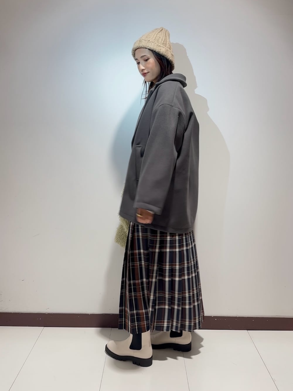 ホワイト系のTシャツ/カットソー、ブルー系のスカート、グリーン系のハンドバッグを着用したレディースの冬コーディネートの2枚目の写真