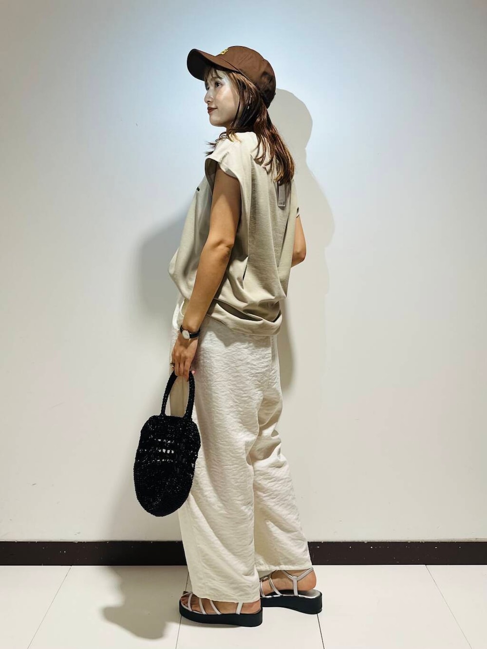 シルバー系のサンダル、ホワイト系のその他パンツ、ベージュ系のTシャツ/カットソーを着用したレディースの夏コーディネートの3枚目の写真