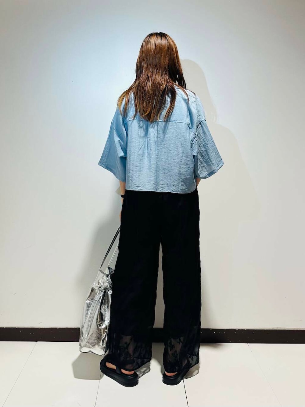 シルバー系のトートバッグ、ブラック系のその他パンツ、ホワイト系のタンクトップを着用したレディースの春コーディネートの4枚目の写真