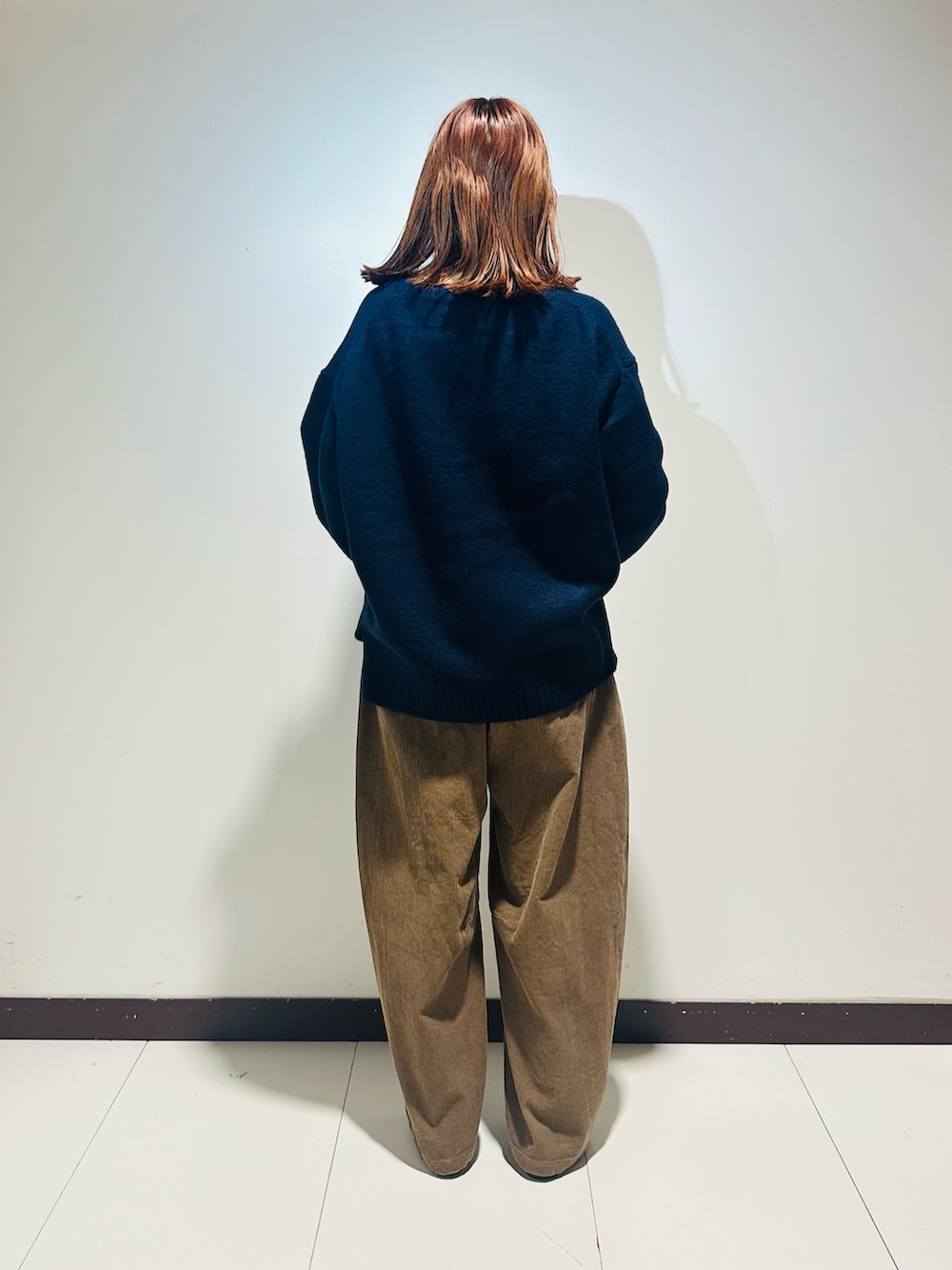 ブルー系のニット/セーター、ベージュ系のその他パンツ、ブラック系のショルダーバッグを着用したレディースの秋コーディネートの4枚目の写真