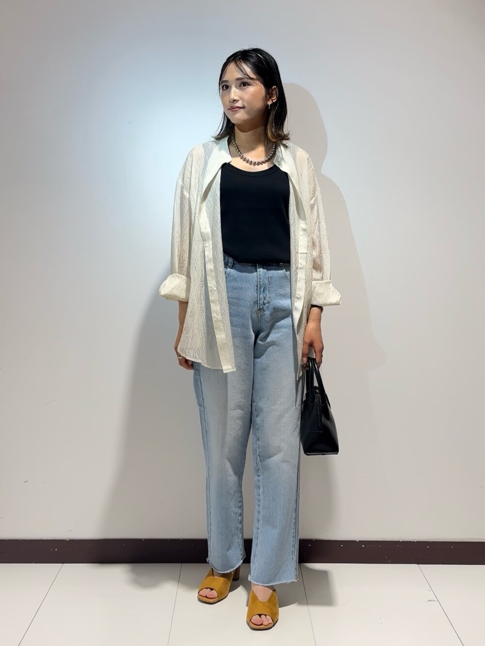 ホワイト系のシャツ/ブラウス、ブラック系のタンクトップ、ブルー系のデニムパンツを着用したレディースの夏コーディネートの2枚目の写真