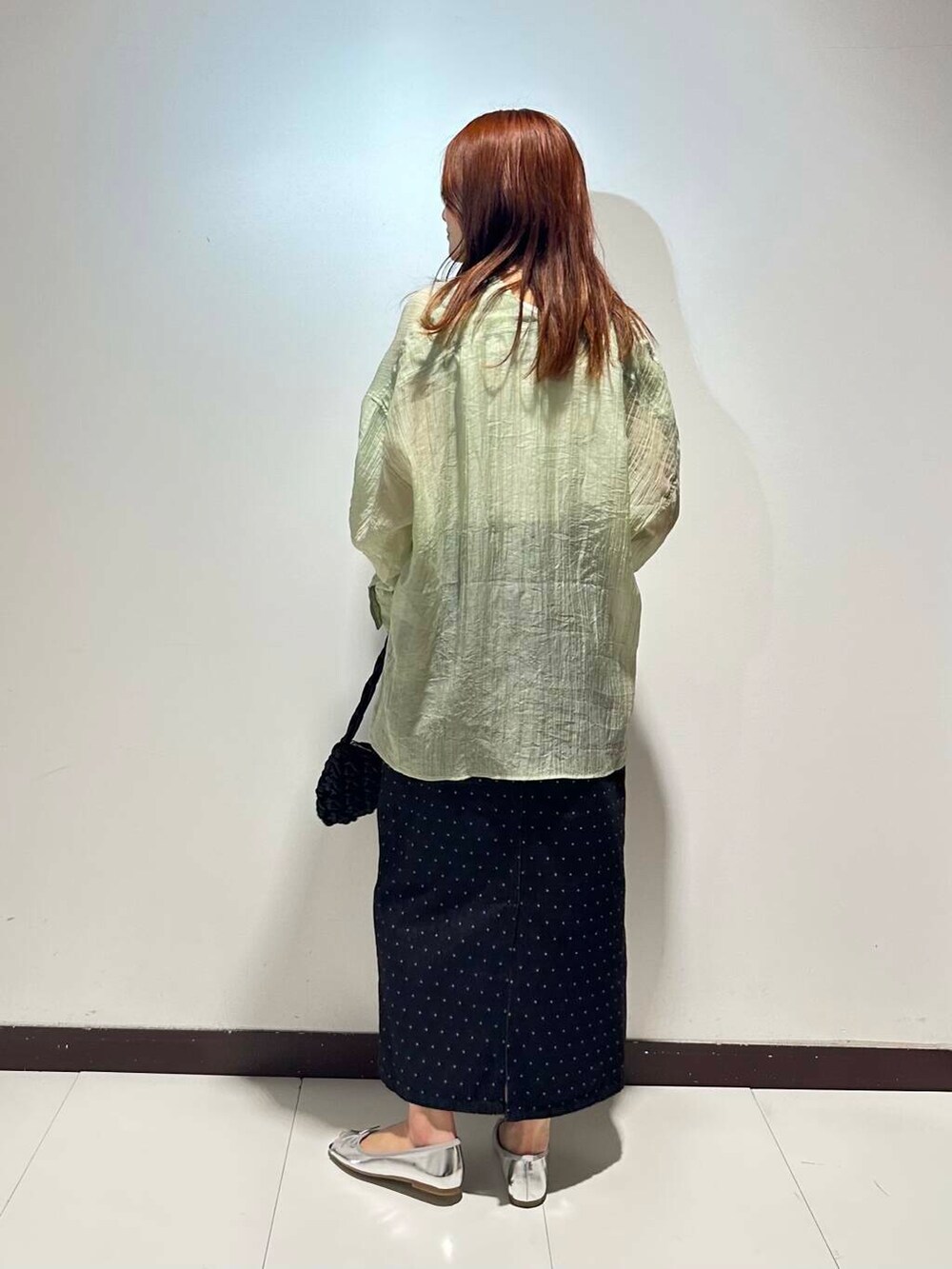 ブラック系のハンドバッグ、シルバー系のパンプス、グリーン系のシャツ/ブラウスを着用したレディースの春コーディネートの3枚目の写真