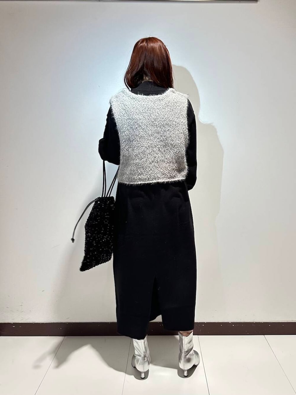 ブラック系のワンピース、グレー系のベストを着用したレディースの冬コーディネートの3枚目の写真