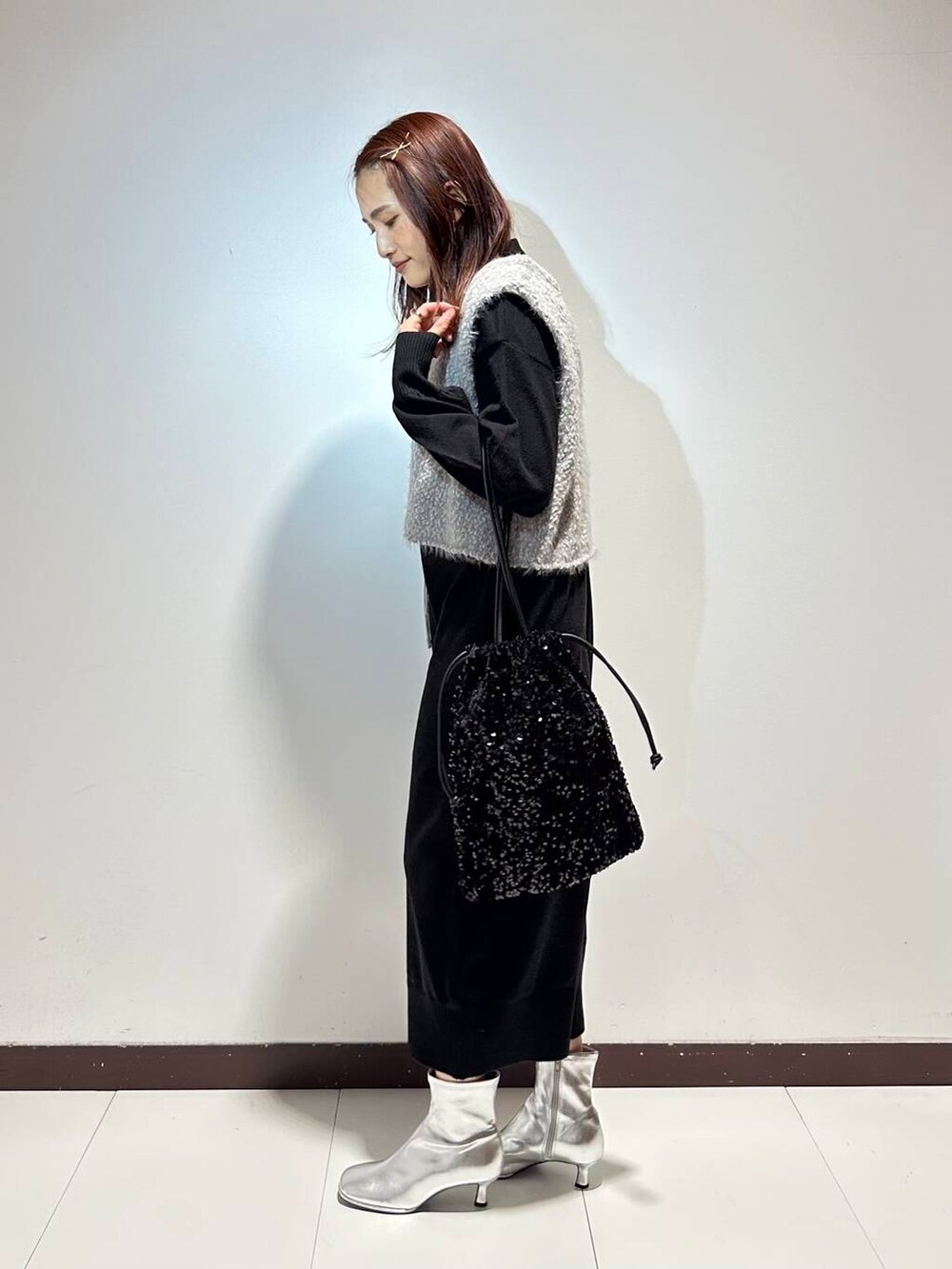 ブラック系のワンピース、グレー系のベストを着用したレディースの冬コーディネートの2枚目の写真