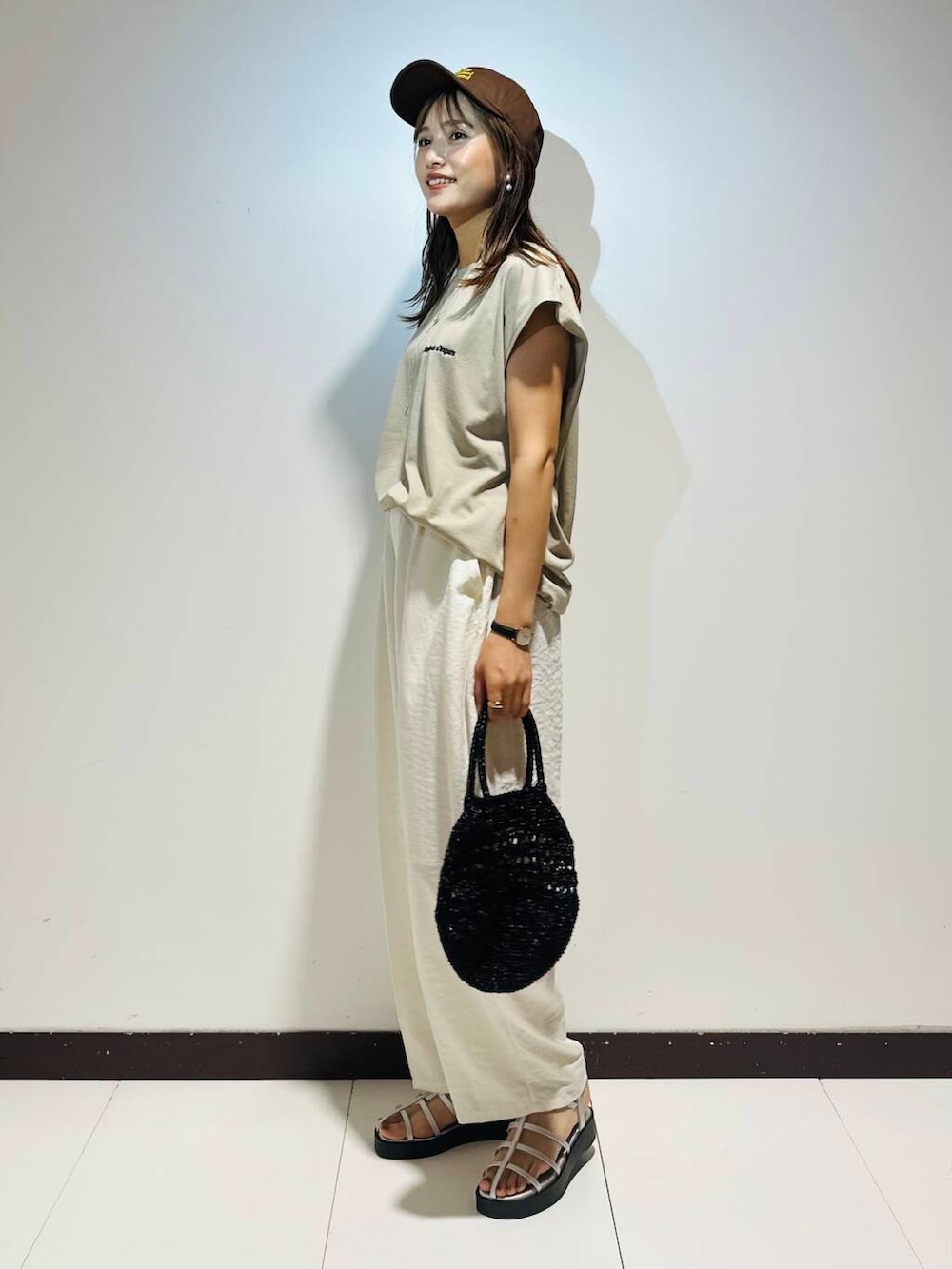 シルバー系のサンダル、ホワイト系のその他パンツ、ベージュ系のTシャツ/カットソーを着用したレディースの夏コーディネートの2枚目の写真