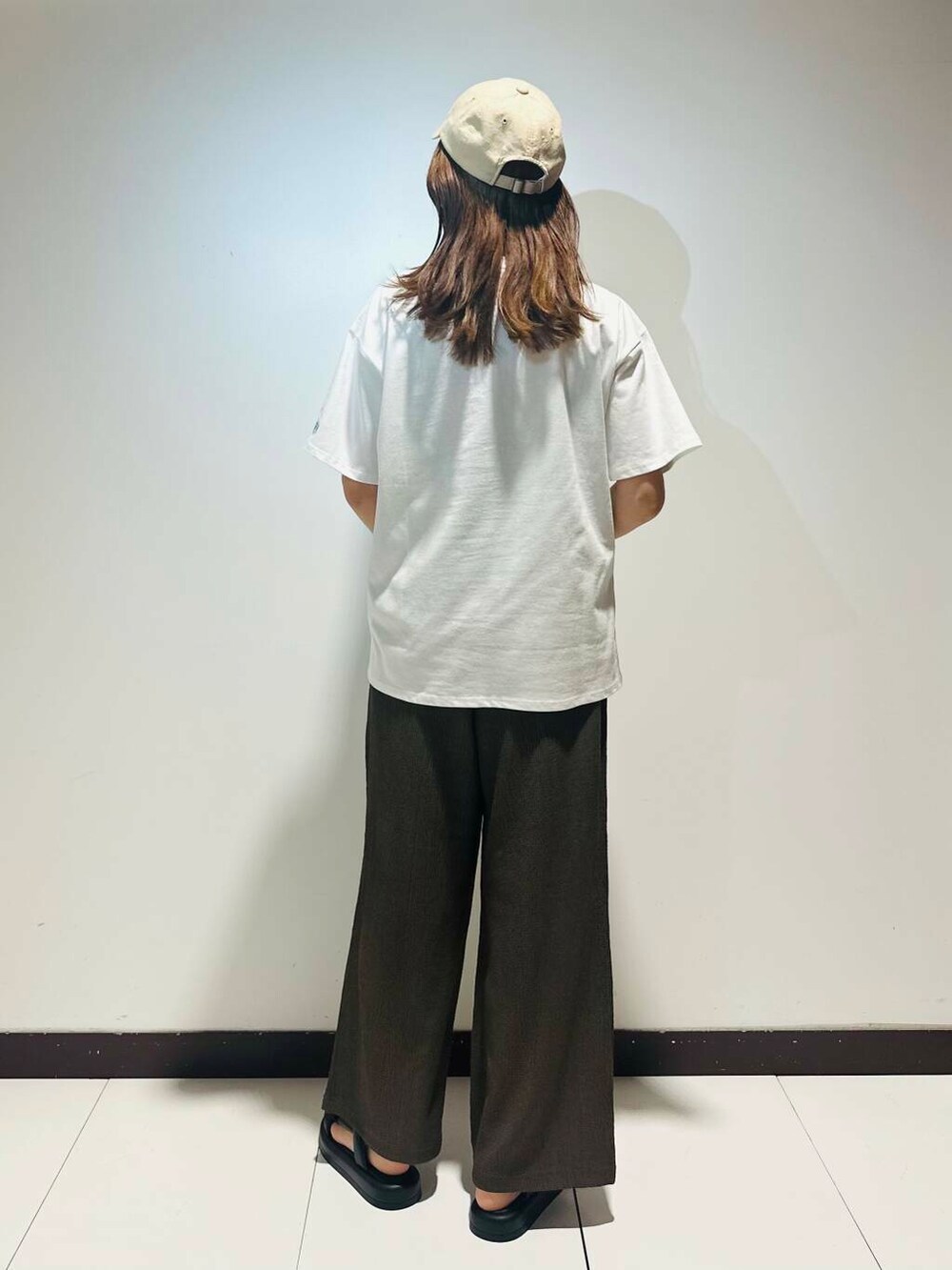 ピンク系のショルダーバッグ、ブラウン系のその他パンツ、ホワイト系のTシャツ/カットソーを着用したレディースの夏コーディネートの3枚目の写真