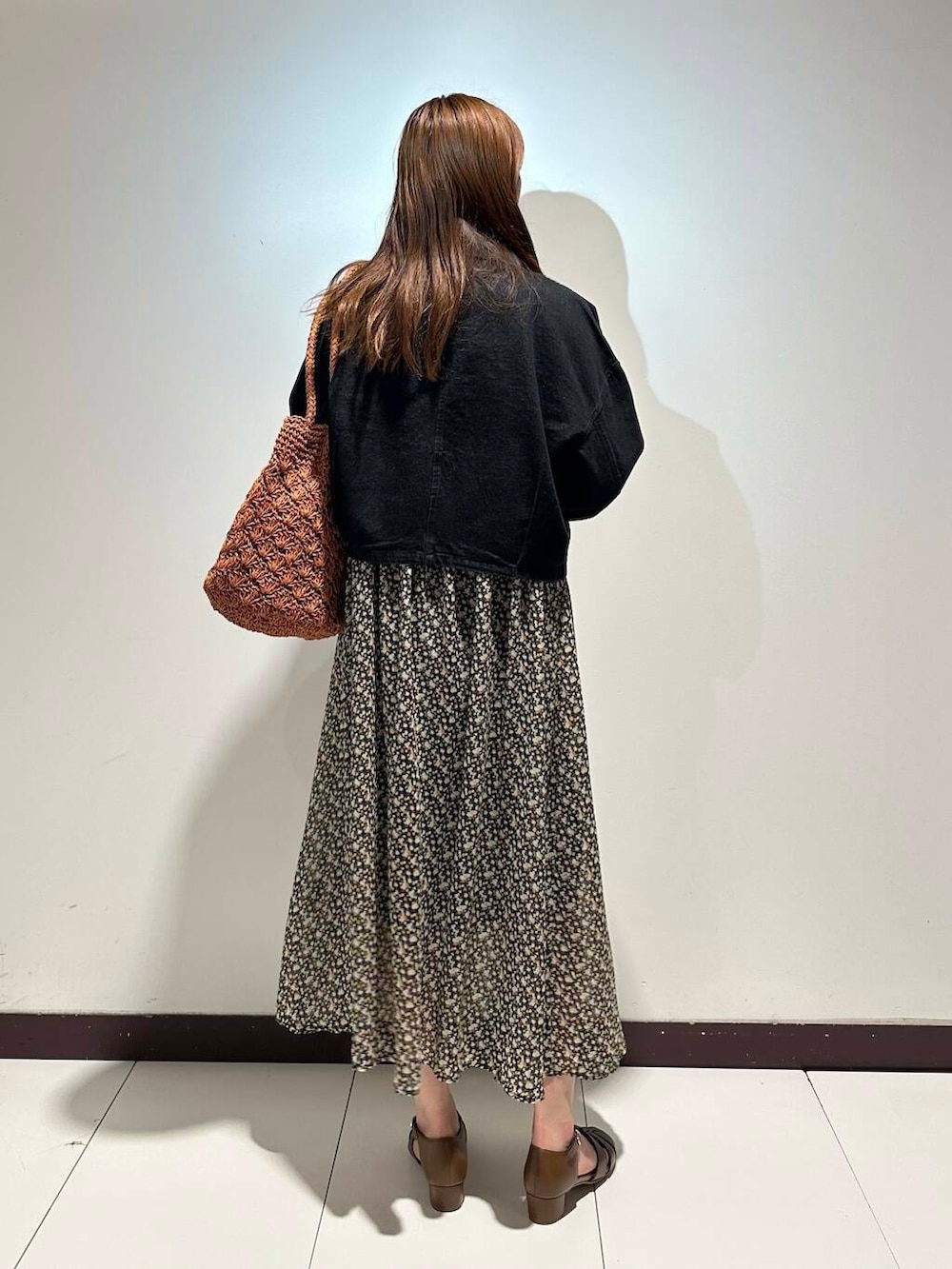 イエロー系のサンダル、オレンジ系のトートバッグ、ブラック系のデニムジャケットを着用したレディースの春コーディネートの3枚目の写真