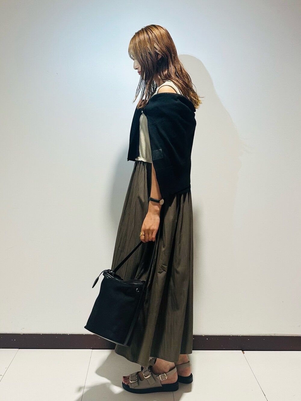 グレー系のワンピース、ブラック系のカーディガン/ボレロ、ブラック系のショルダーバッグを着用したレディースの夏コーディネートの2枚目の写真