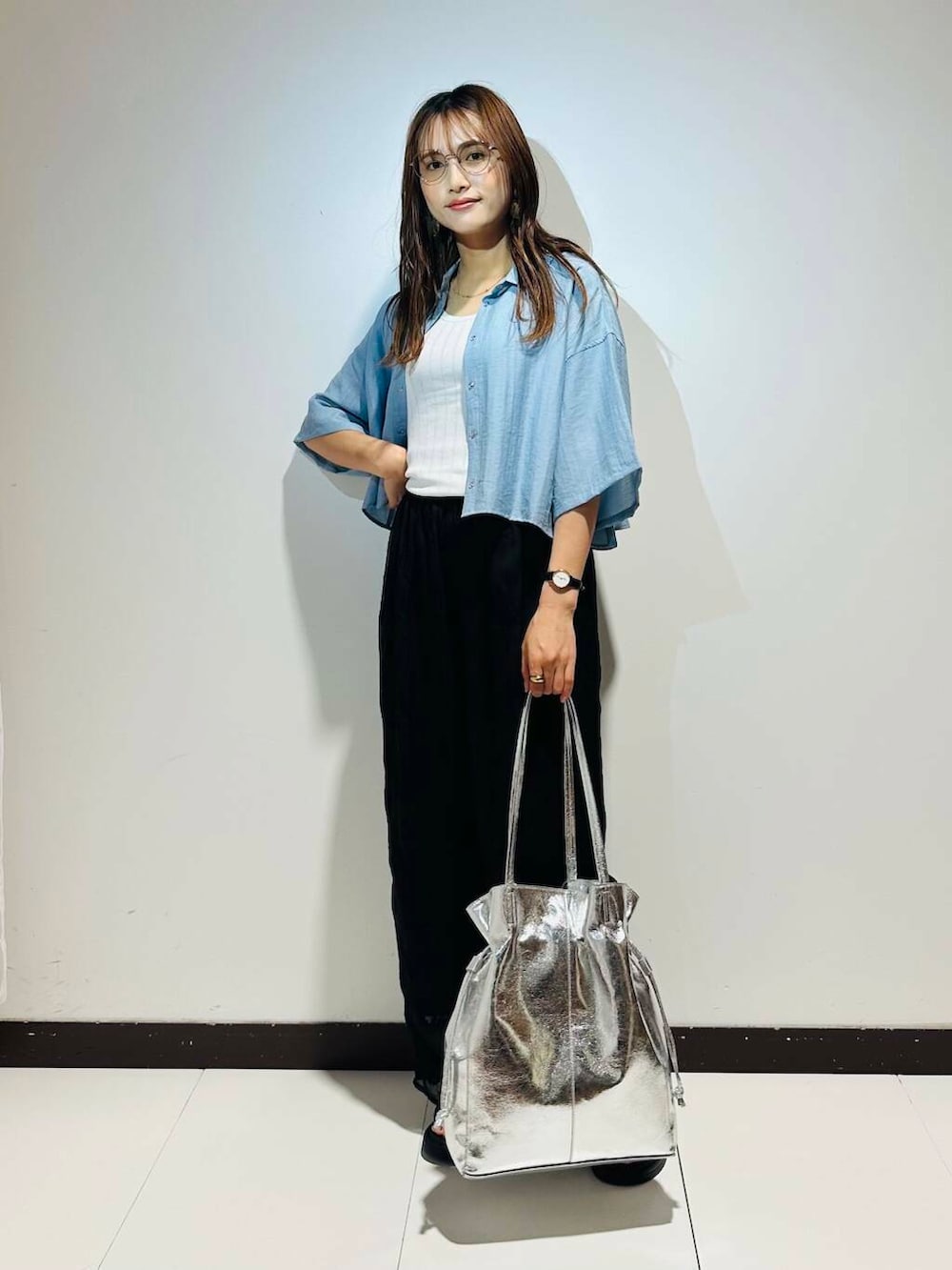 シルバー系のトートバッグ、ブラック系のその他パンツ、ホワイト系のタンクトップを着用したレディースの春コーディネートの2枚目の写真