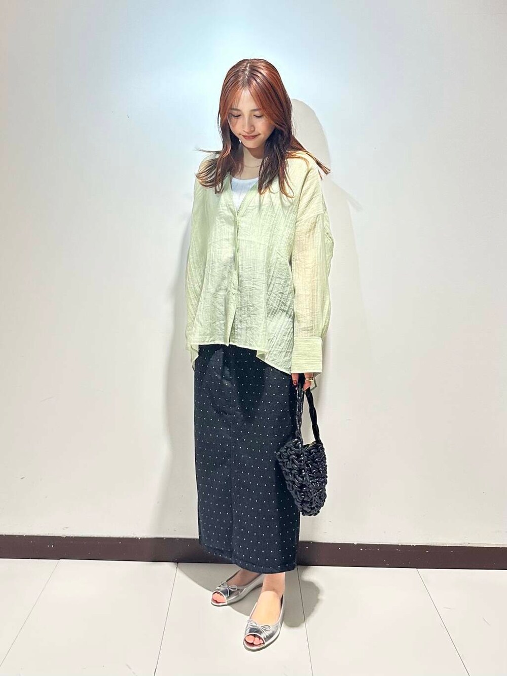 ブラック系のハンドバッグ、シルバー系のパンプス、グリーン系のシャツ/ブラウスを着用したレディースの春コーディネートの2枚目の写真