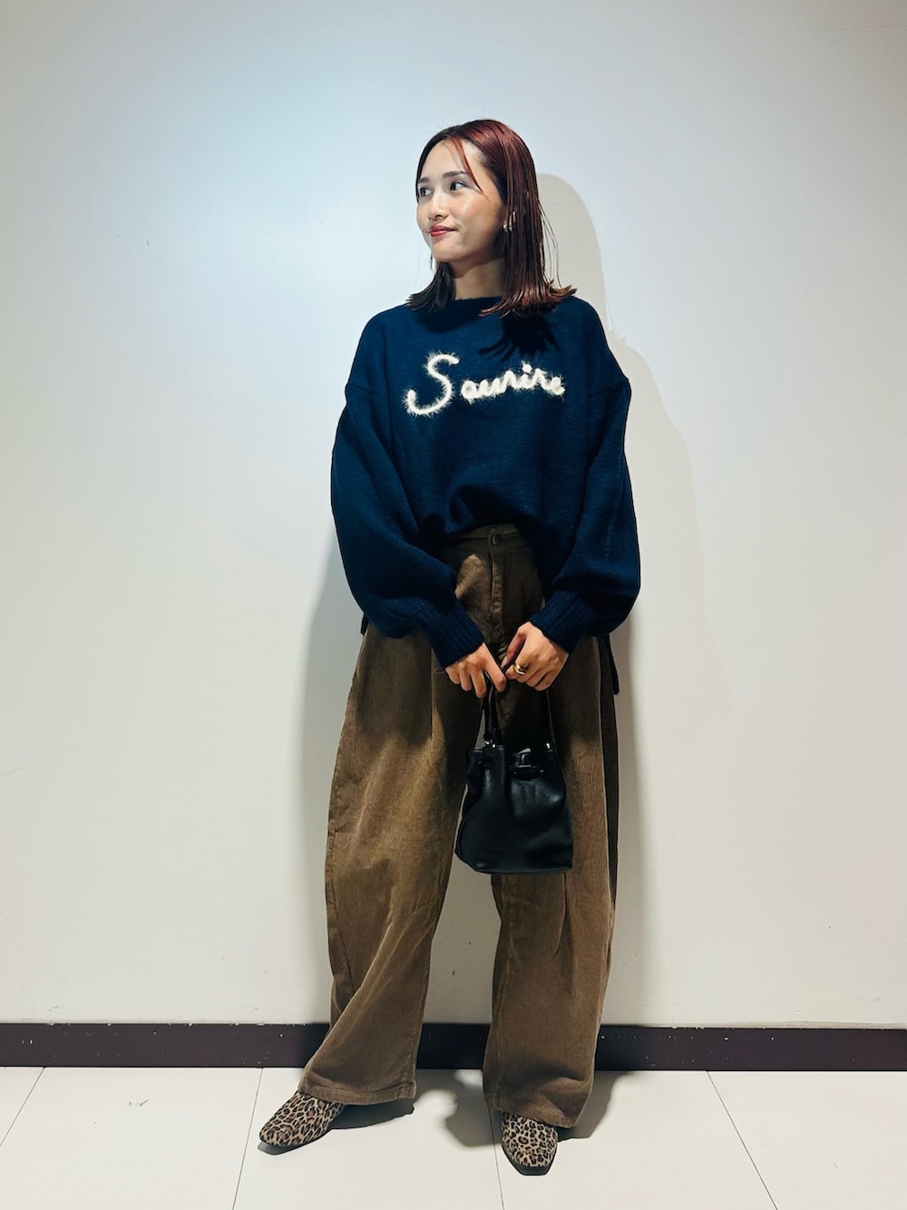 ブルー系のニット/セーター、ベージュ系のその他パンツ、ブラック系のショルダーバッグを着用したレディースの秋コーディネートの2枚目の写真