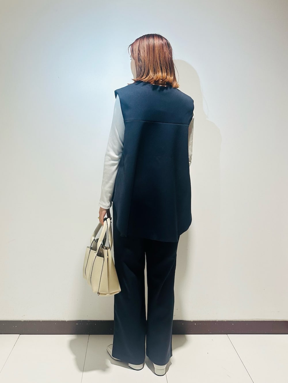 ホワイト系のトートバッグ、ブルー系のセットアップ、グレー系のローファーを着用したレディースの冬コーディネートの3枚目の写真